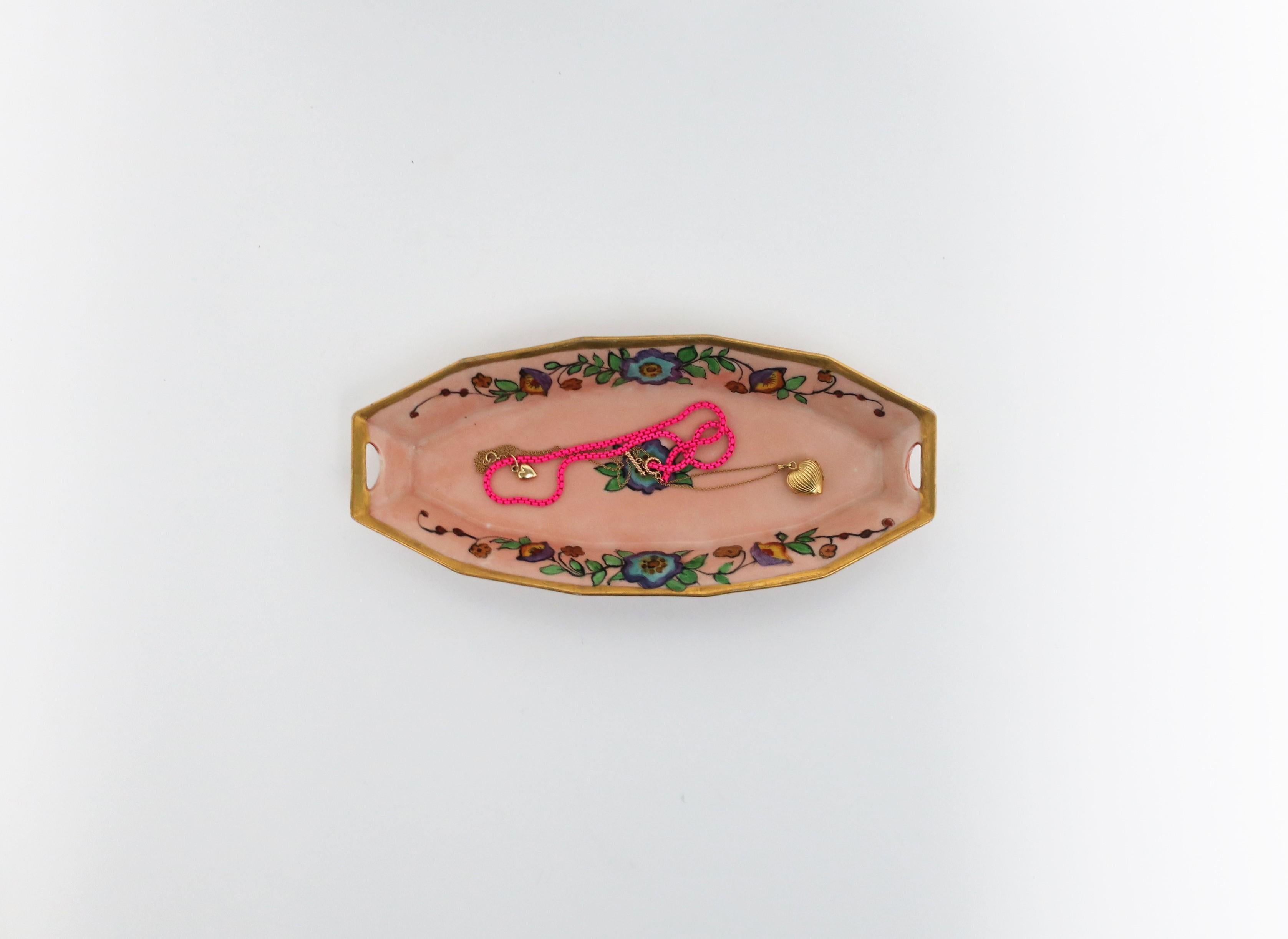 A beautiful Austrian Art Nouveau porcelain pink and gold oblong dish, circa early 20th century, Austria. Piece has hand painted design of flowers and leaves at center and on sides, finished with a shimmering gold edge. Beautiful as a standalone