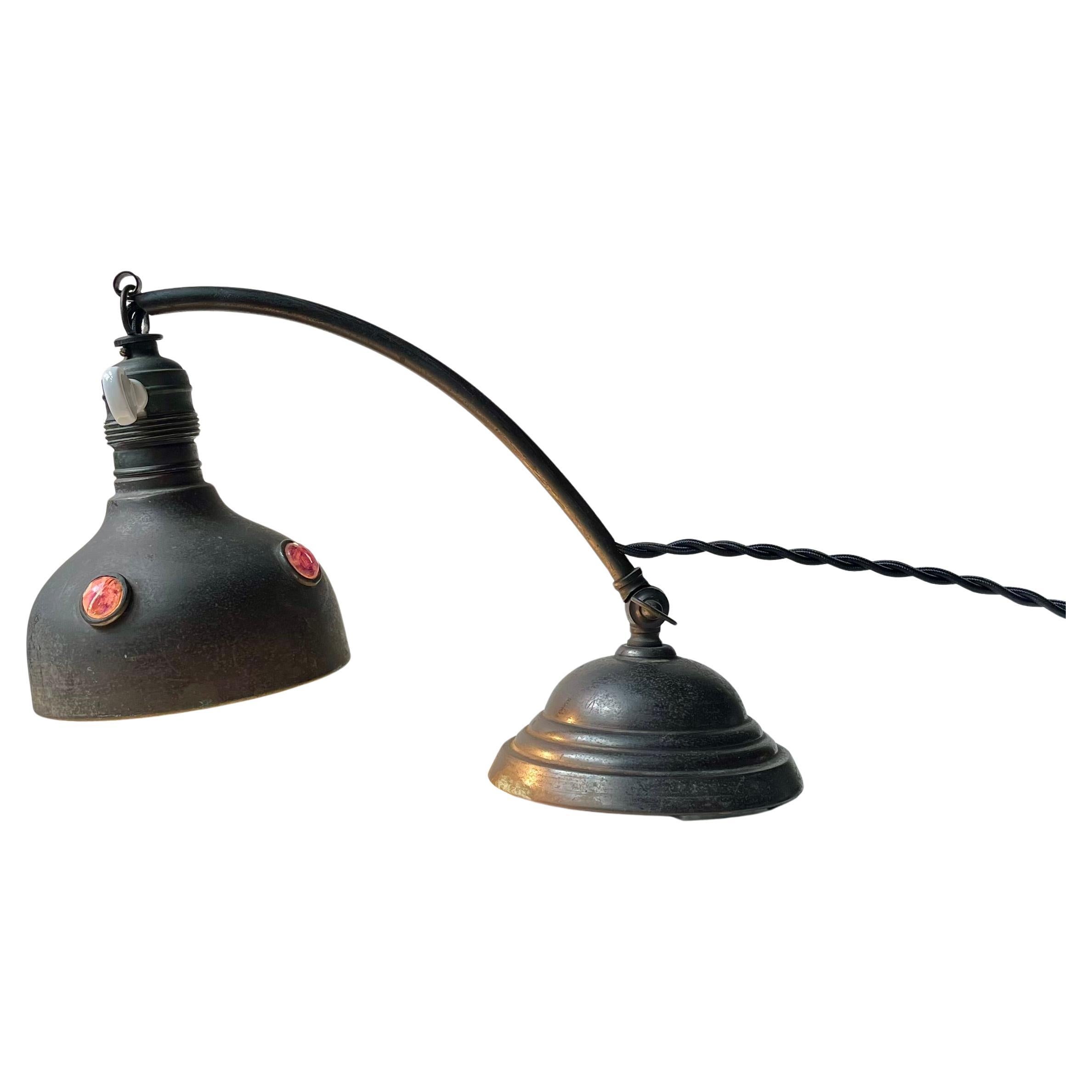 Lampe de table ou de bureau antique en laiton patiné naturellement et sertie d'inserts de verre à facettes violet - rose lorsque le couvercle est en place. Cette lampe a été fabriquée à Vienne en Autriche vers 1910-1920. D'un point de vue