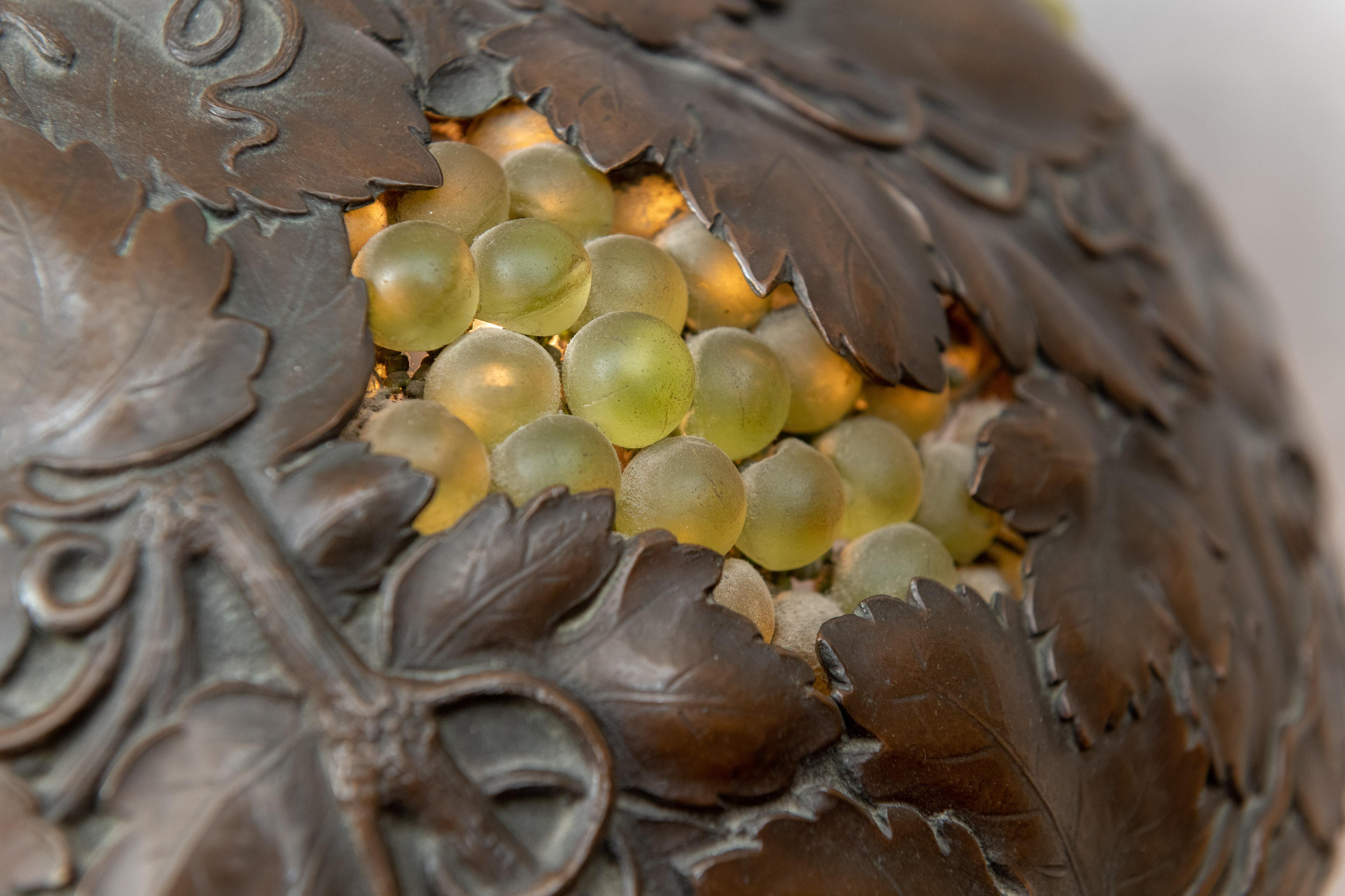 This is one of the best and most exotic lamps we have offered in a long time. The quality of the casting is very special. That lizard looks real, right down to the skin. The shade is very naturalistic and lights behind bunches of glass grapes. The