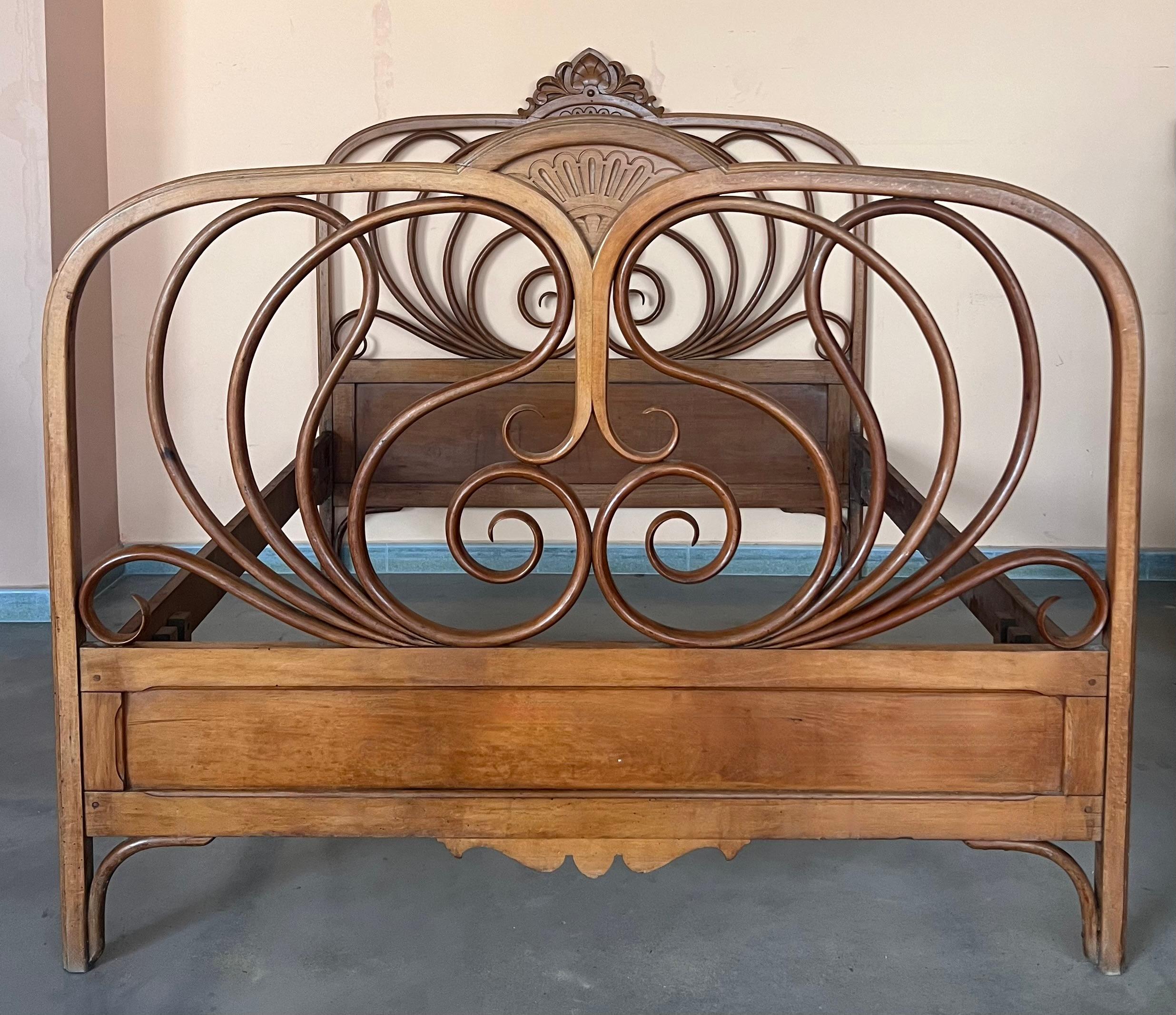 Designed by J & J Kohn, this mahogany stained bentwood bed features curved head and footboards swelling with decorative scroll form tendrils.  
J & J Kohn, No. 876, 1900 Catalog.

Height from the floor to the rails: 15.75in
Headboard Height: 48.45in
