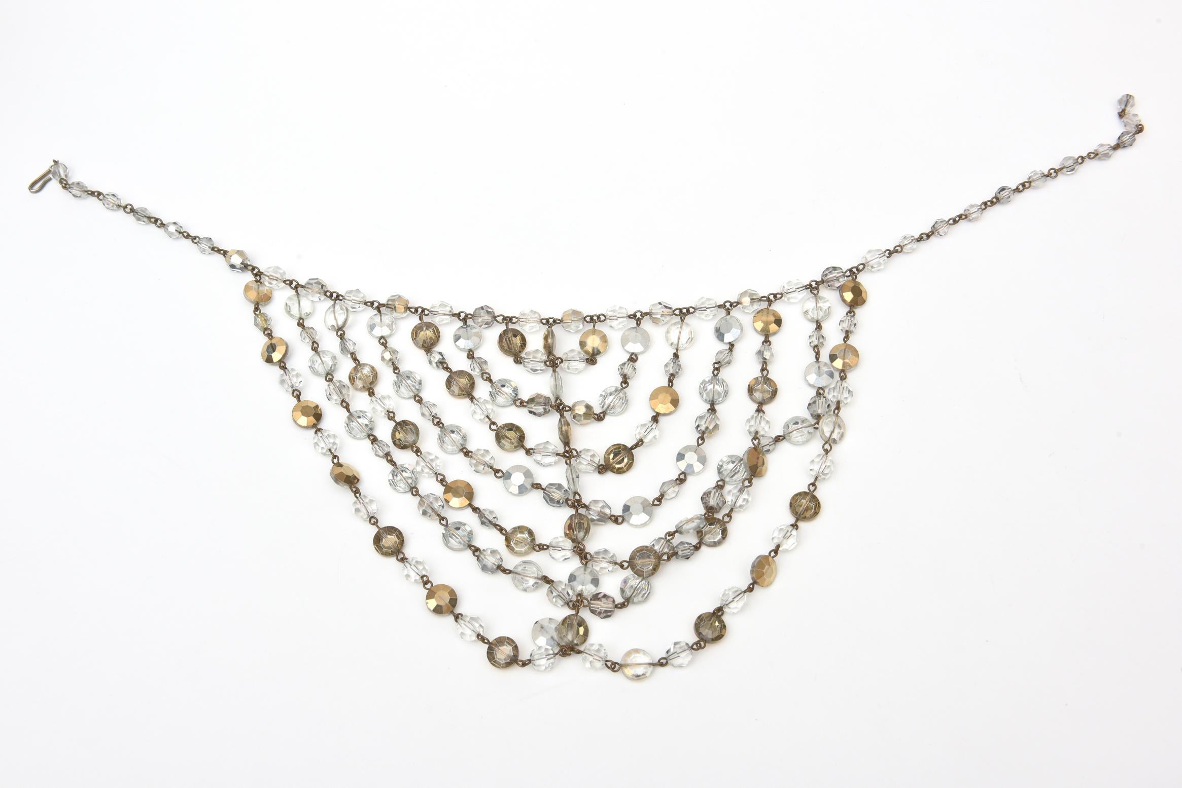 This stunning versatile vintage tiered bib necklace has layers of Austrian bevel cut crystals hanging it tiers in a bib necklace form. They are gold and clear crystals. This is a dramatic and dressy necklace on. One can make it closer or looser on