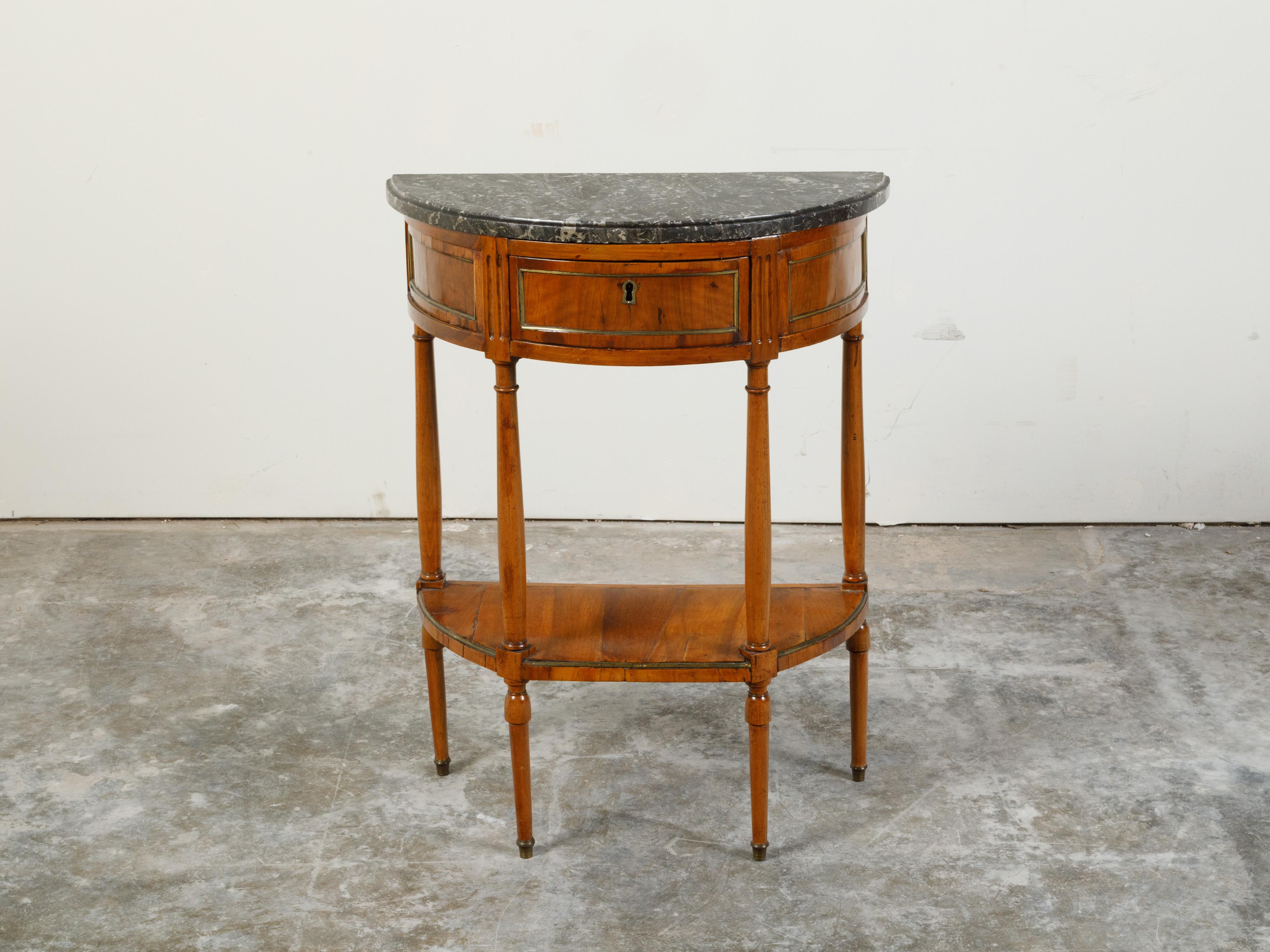 An Austrian Biedermeier period walnut demilune console table from the mid 19th century, with brass inlay and marble top. Created in Austria during the Biedermeier period, this walnut table features a semicircular dark grey veined marble top sitting