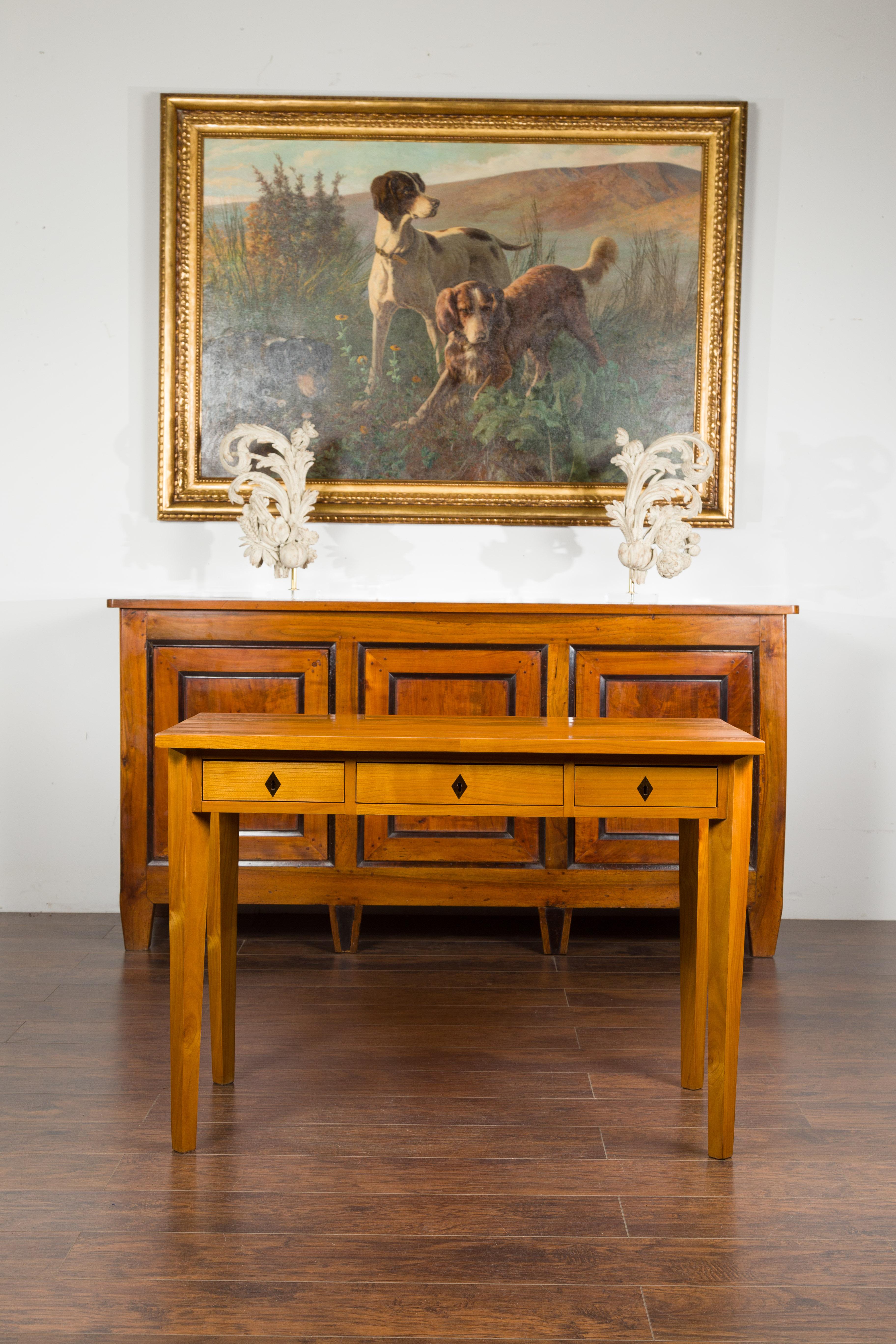 A Biedermeier period walnut desk from the mid-19th century, with three drawers and blond patina. Created in Austria during the second quarter of the 19th century, this Biedermeier walnut table features a rectangular top sitting above three