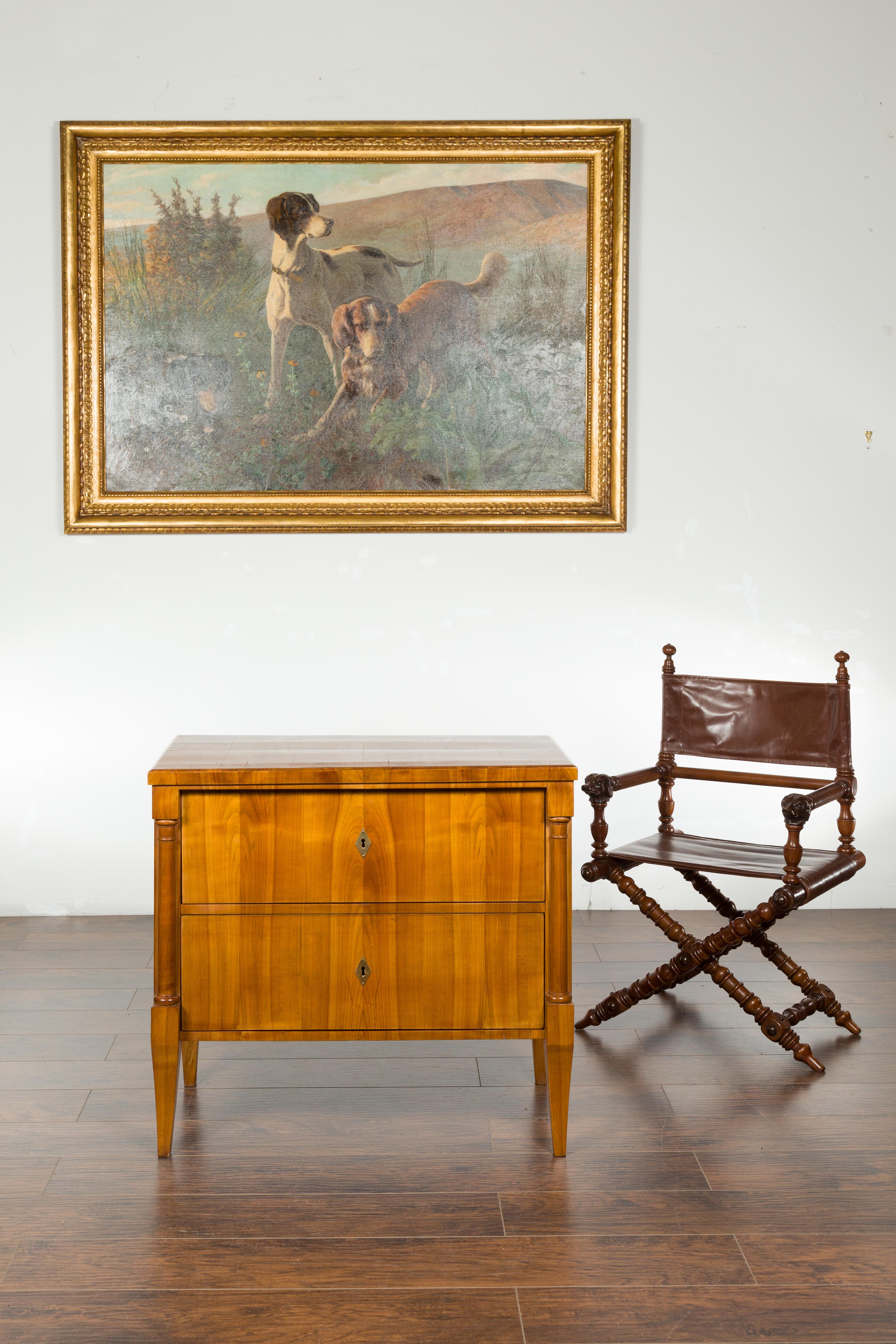 An Austrian Biedermeier period walnut commode from the mid-19th century, with two drawers and semi-columns. Created in Austria during the Biedermeier period, this walnut veneered commode features a rectangular top sitting above two drawers, fitted