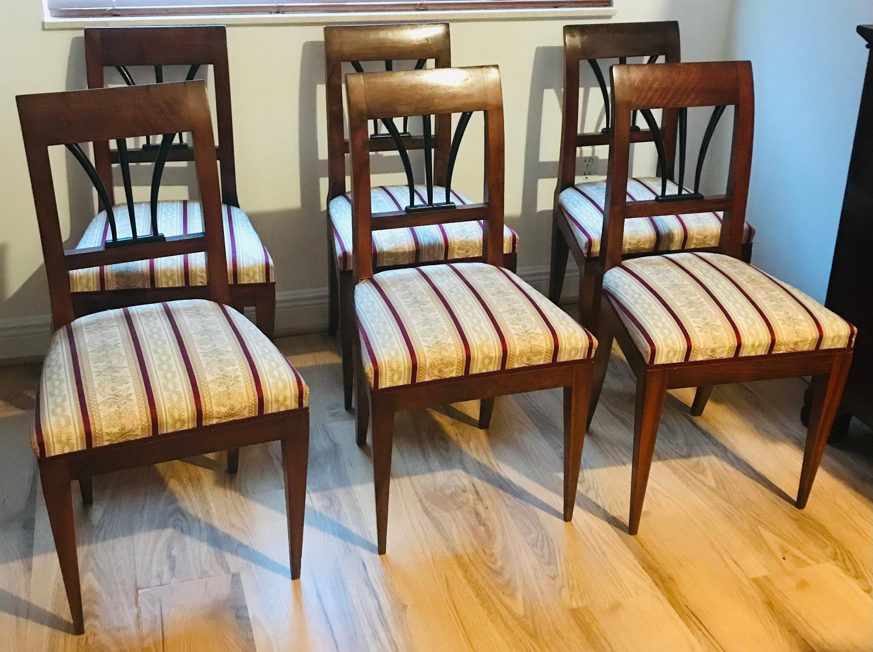 Set di 6 sedie da pranzo Biedermeier austriache. In legno massiccio di noce, lavorato a mano. Tutte le condizioni originali, con lucidatura a gommalacca. Rivestito in tessuto a righe in stile Biedermeier. È raro trovare un set di 6 sedie in queste