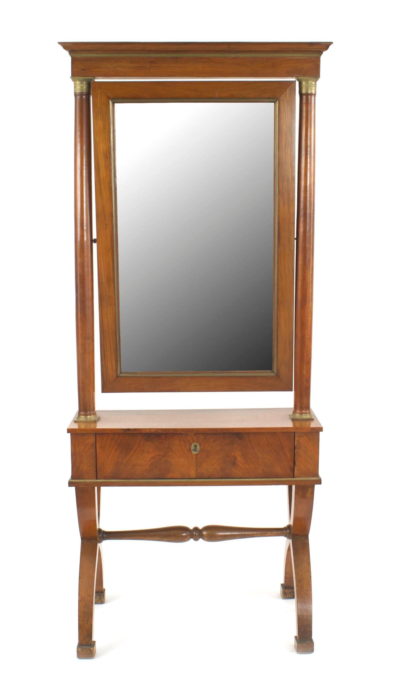 Austrian Biedermeier (Circa 1835) cherrywood cheval mirror on a stand with a drawer, a cross leg base, and column sides.
