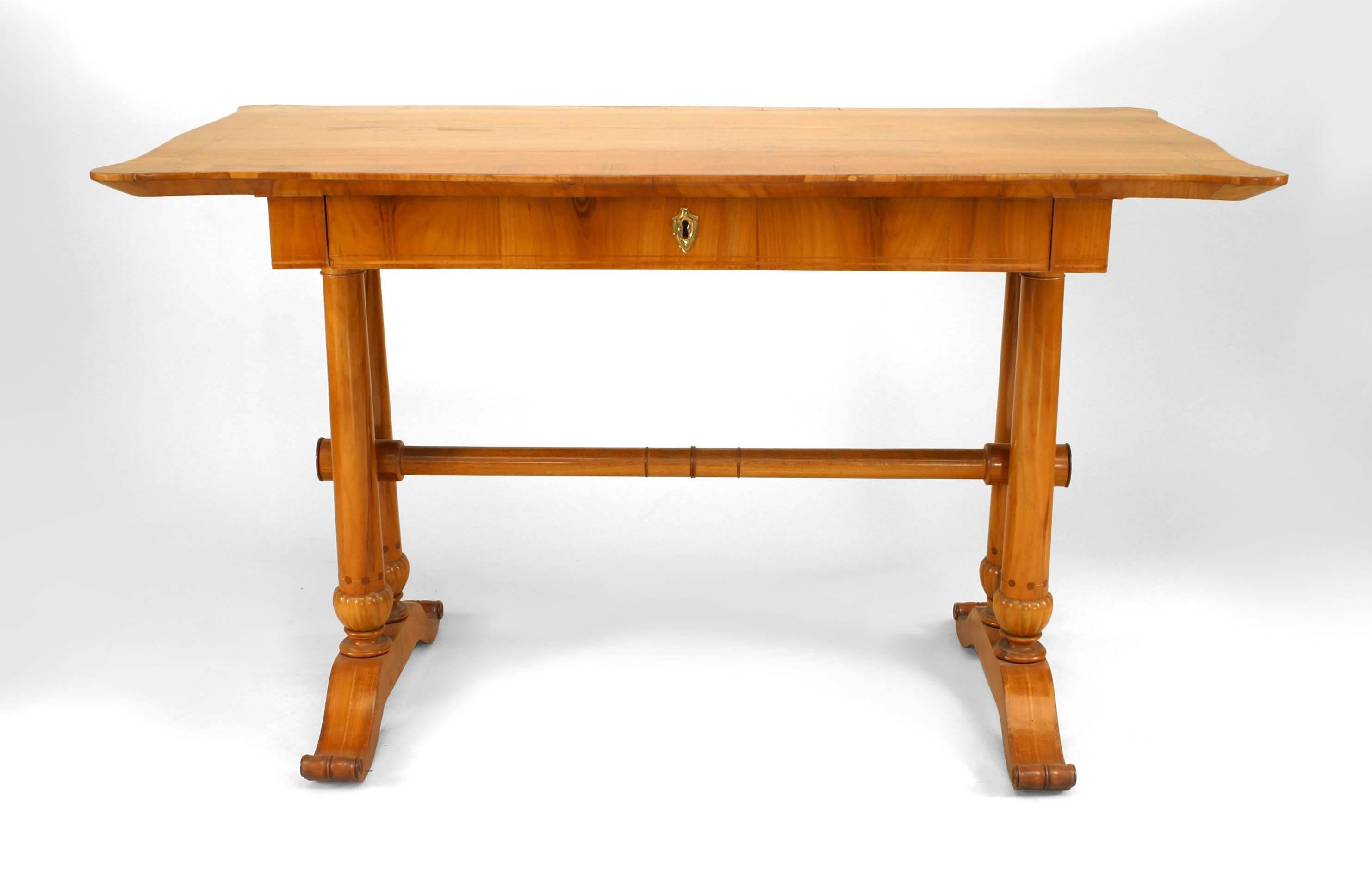 Austrian Biedermeier table desk composed of cherrywood and inlaid banding with a double pedestal base joined by a rod stretcher beneath a shaped rectangular top fitted with a single drawer.