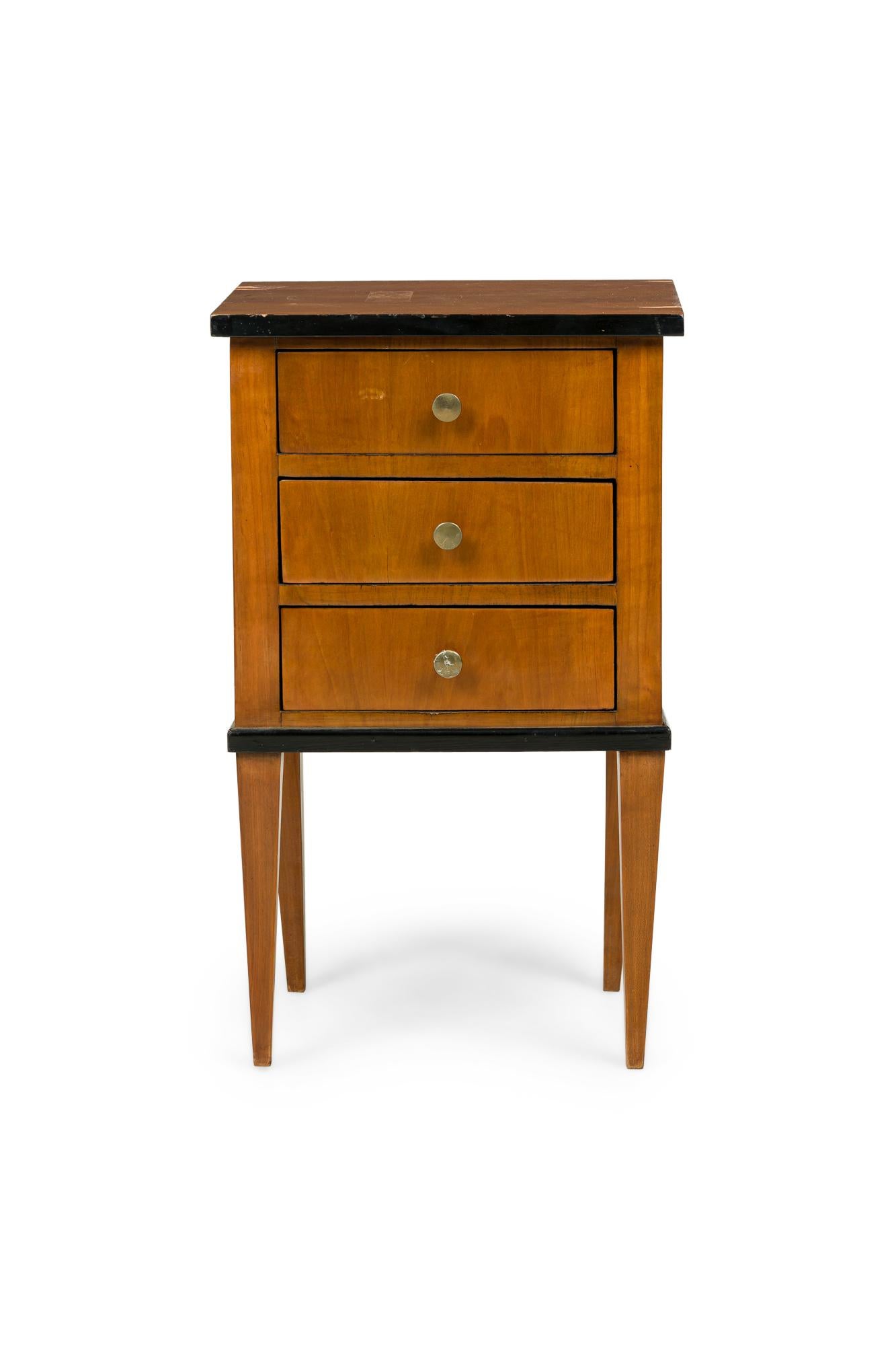 Österreichische Biedermeier Nachttischkommode aus Kirschbaumholz mit schwarzer Zierleiste und 3 Schubladen mit runden Schubladengriffen aus Messing (Furnierausgaben auf der Oberseite)