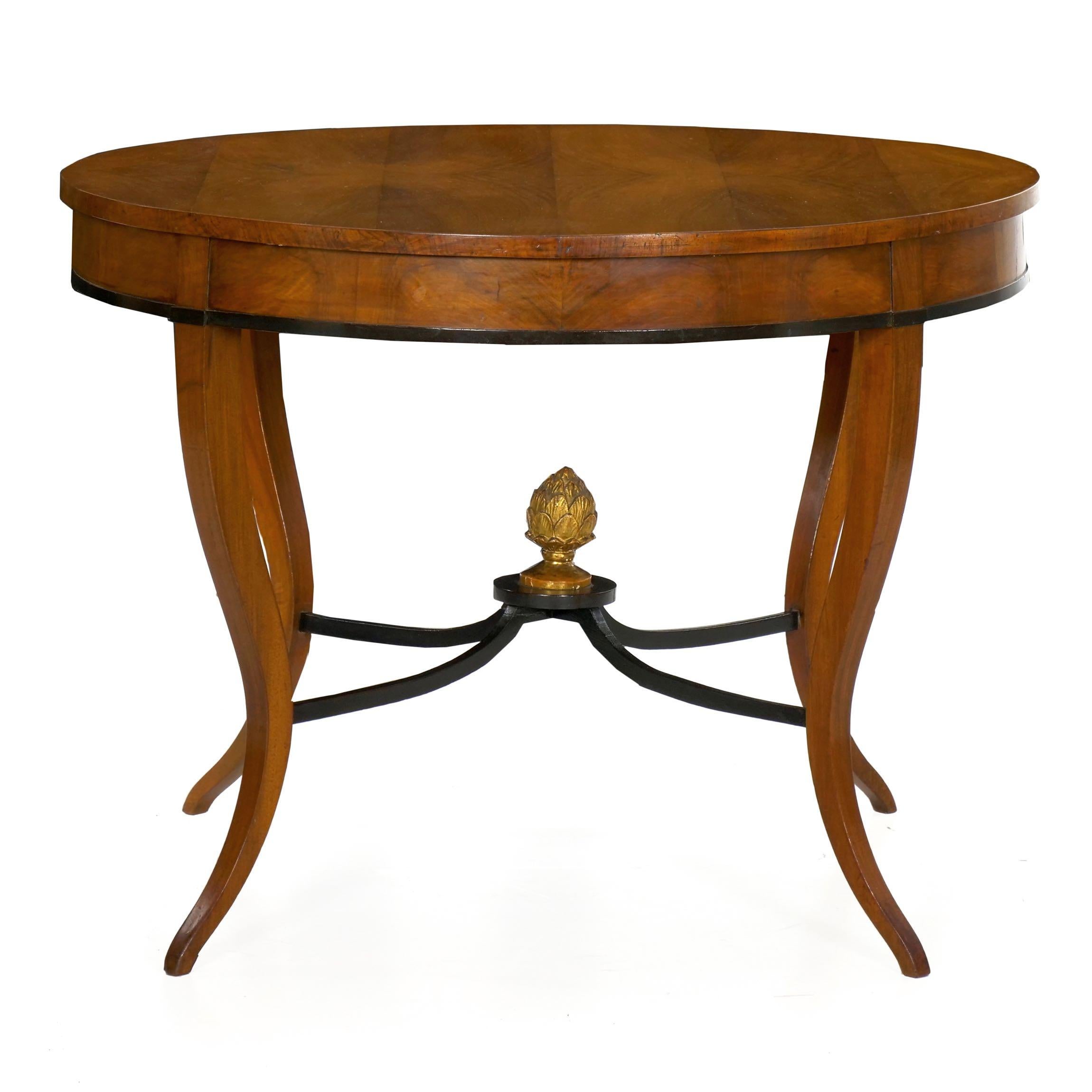 A very elegant form with a lightness of profile that is most admirable, this Fine center table exhibits a skilled matching of veneers throughout. The top is arranged in six book-matched bands of alternating hues of fruitwood, allowing for a stunning