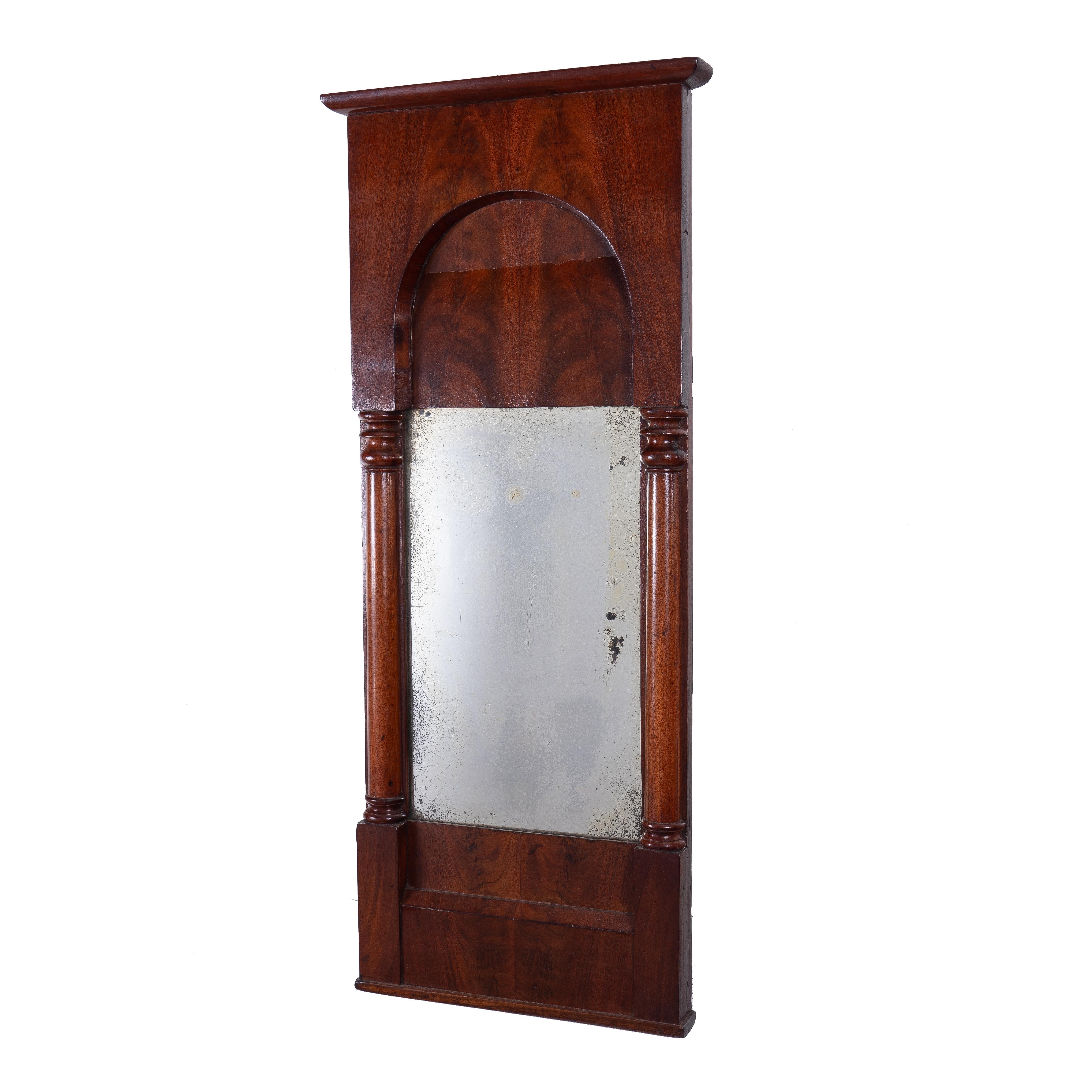 Miroir de pilier Biedermeier en acajou et acajou croche plaqué, avec corniche au-dessus d'un entablement à panneaux et à arcades. L'entablement est soutenu par des demi-colonnes en acajou qui flanquent un miroir au-dessus d'une plinthe