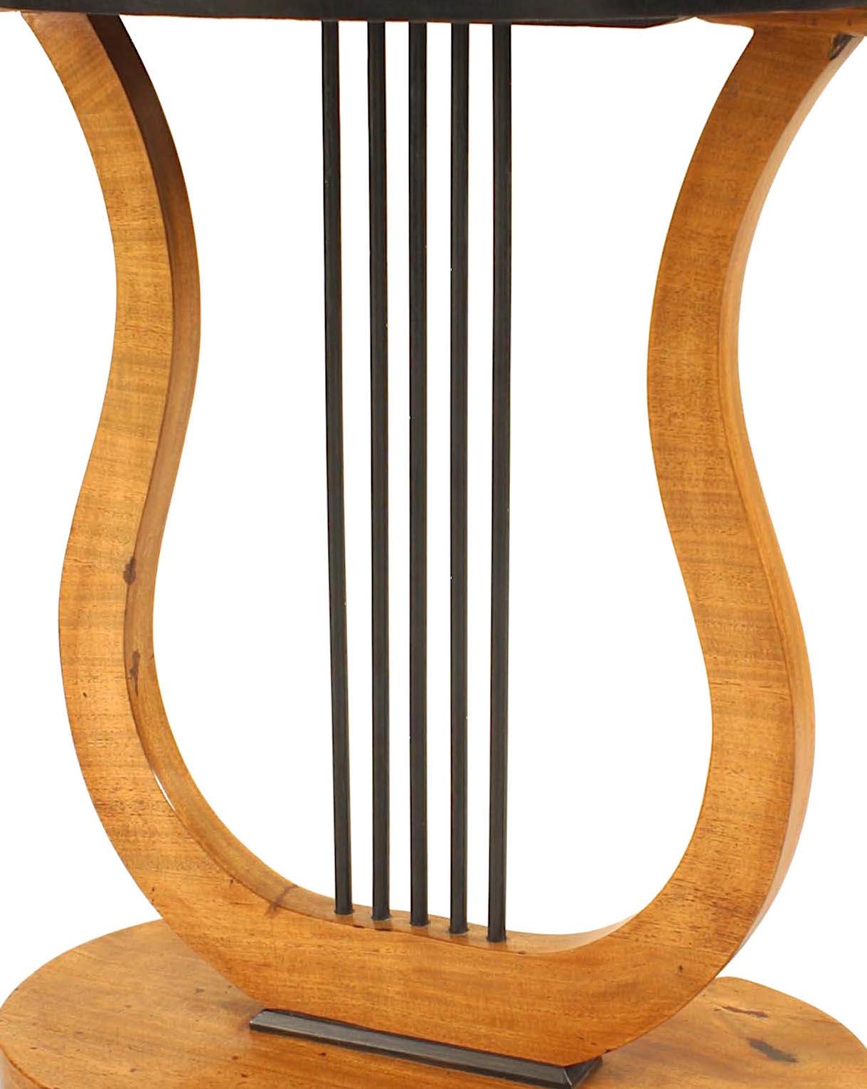 Österreichischer Biedermeier Tisch aus Ahorn und Ebenholz mit einer ovalen Platte, die von einer Lyra Form getragen wird, auf einem ovalen Sockel, der auf 4 kleinen Kugelfüßen ruht.
