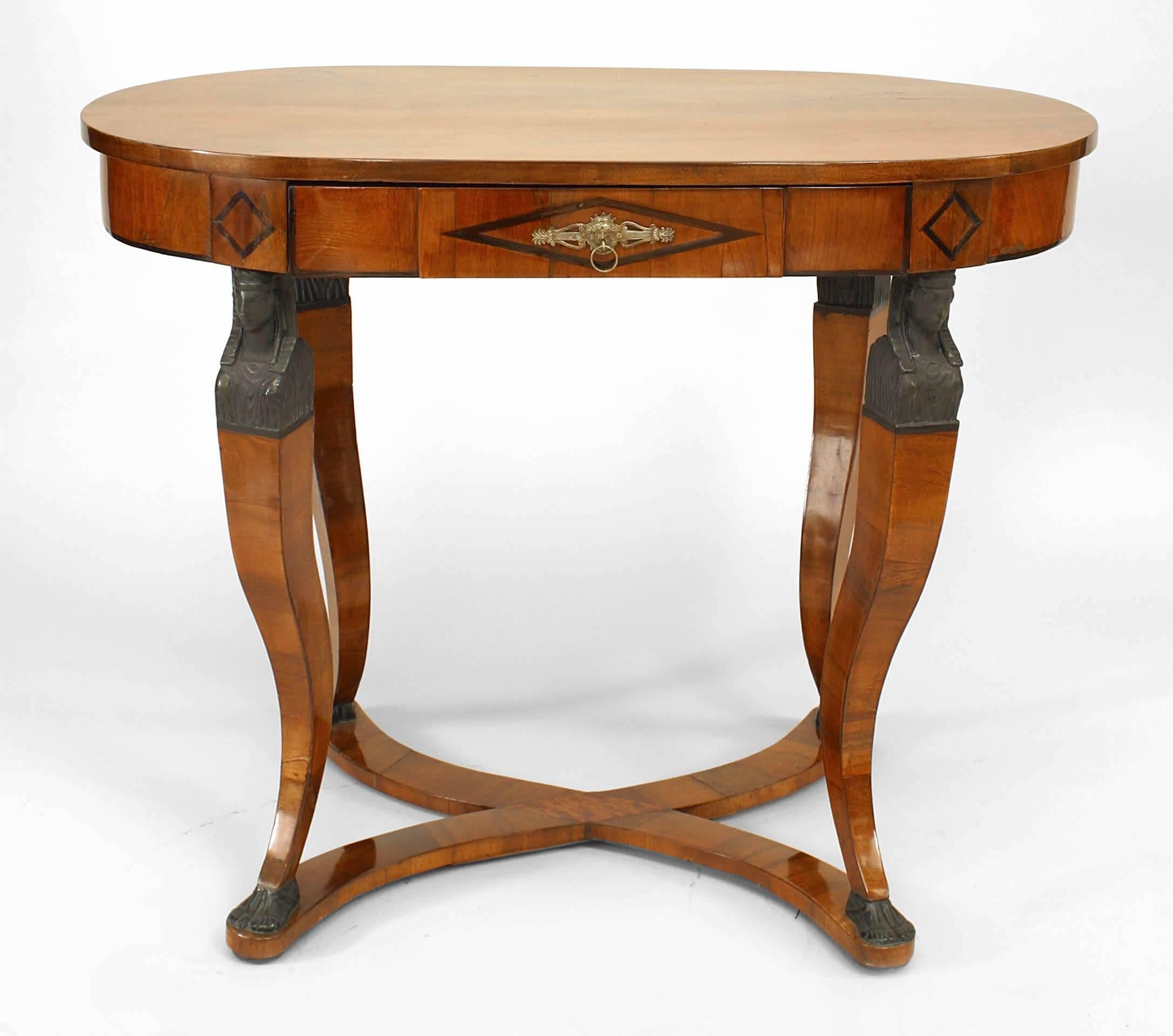 Austrian Biedermeier (Circa 1830) walnut & ebonized trimmed oval center table with drawer and 4 scroll design legs with classical figural heads ending with shaped stretcher.

