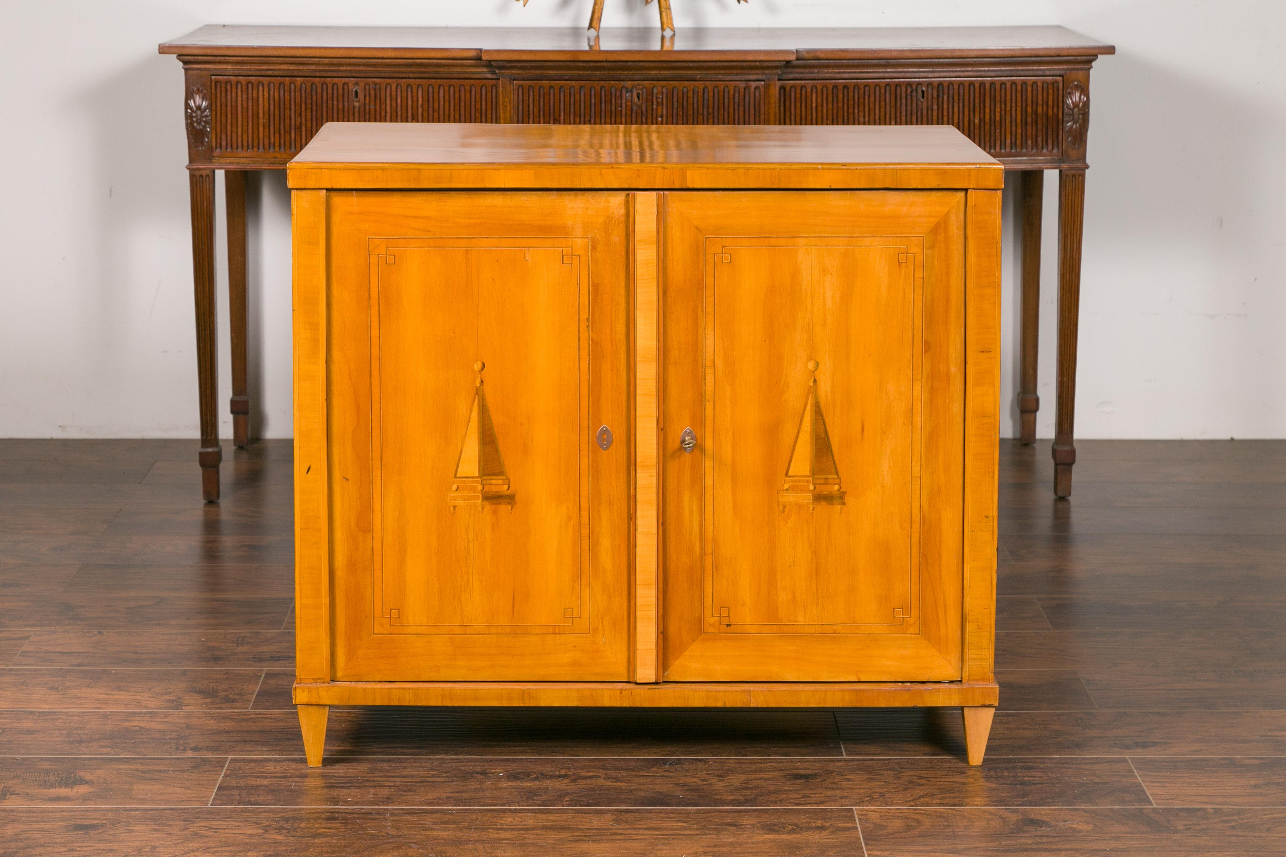 An Austrian Biedermeier period walnut buffet from the mid-19th century, with marquetry motifs and tapered feet. Created in Imperial Austria during the second quarter of the 19th century, this Biedermeier buffet features a rectangular planked top