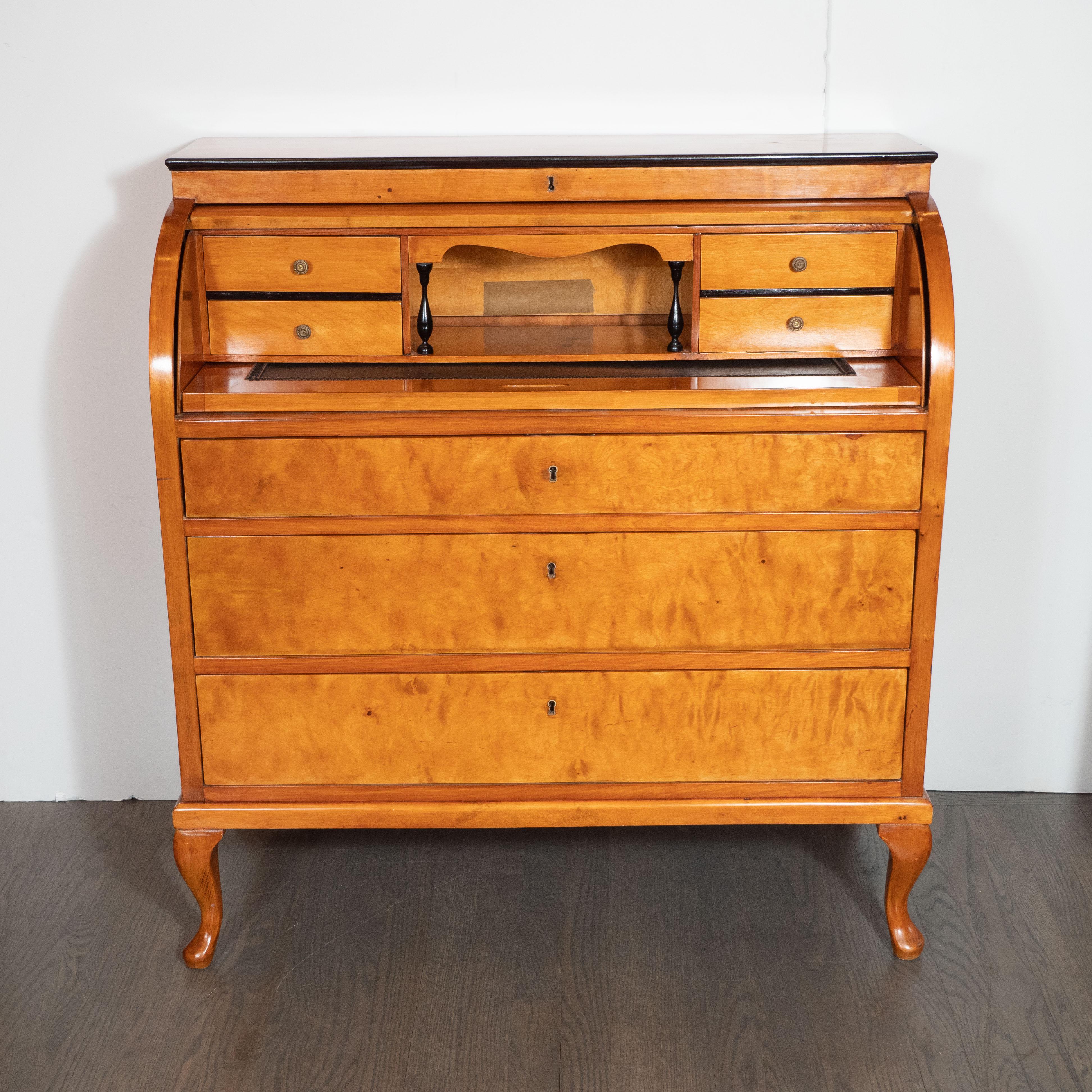 This elegant Biedermeier roll top desk was realized in Vienna Austria, circa 1860. Sitting on cabriolet feet, the piece features a volumetric rectangular body with a slightly protruding apron and gently curved roll top front, and three drawers with