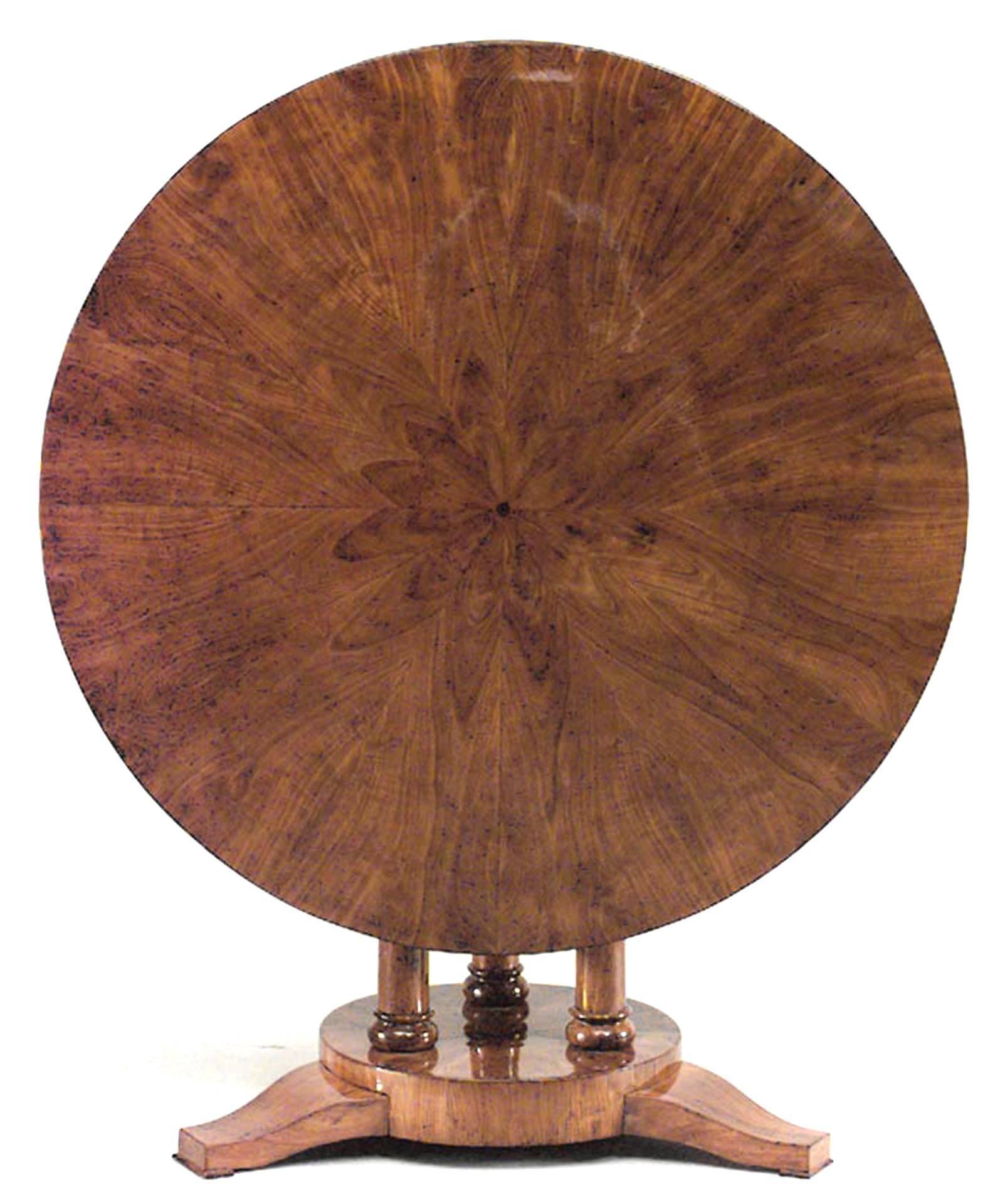 Austrian Biedermeier round walnut tilt-top centre table with sunburst design inlaid top supported on three column pedestal resting on round platform base, circa 1835.
 