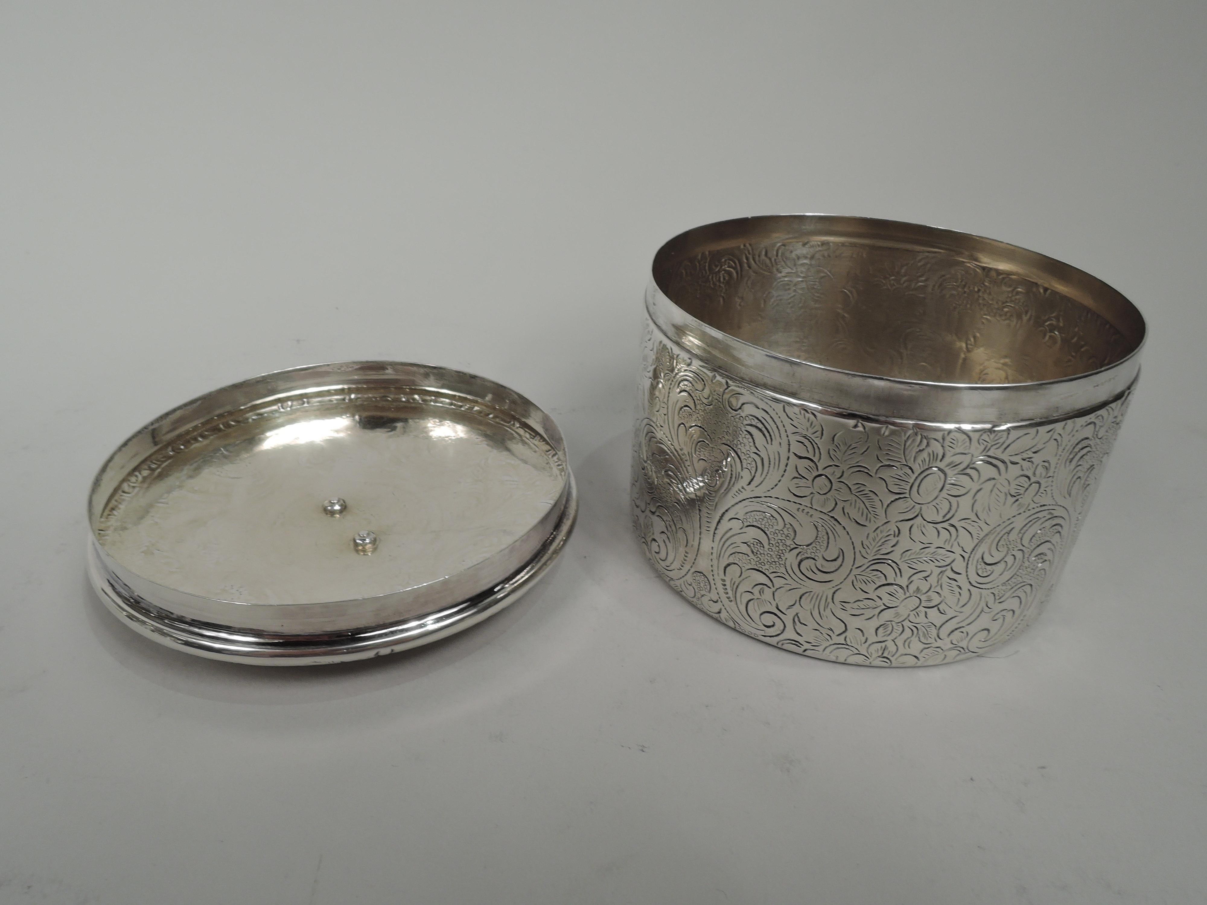 Austrian Biedermeier 812 silver box, 1835. Round with straight sides. Cover has plain sides and gently curved top. Engraved allover pattern with flowers and leafing scrollwork. On cover top is applied oval medallion applied with coronet and coat of