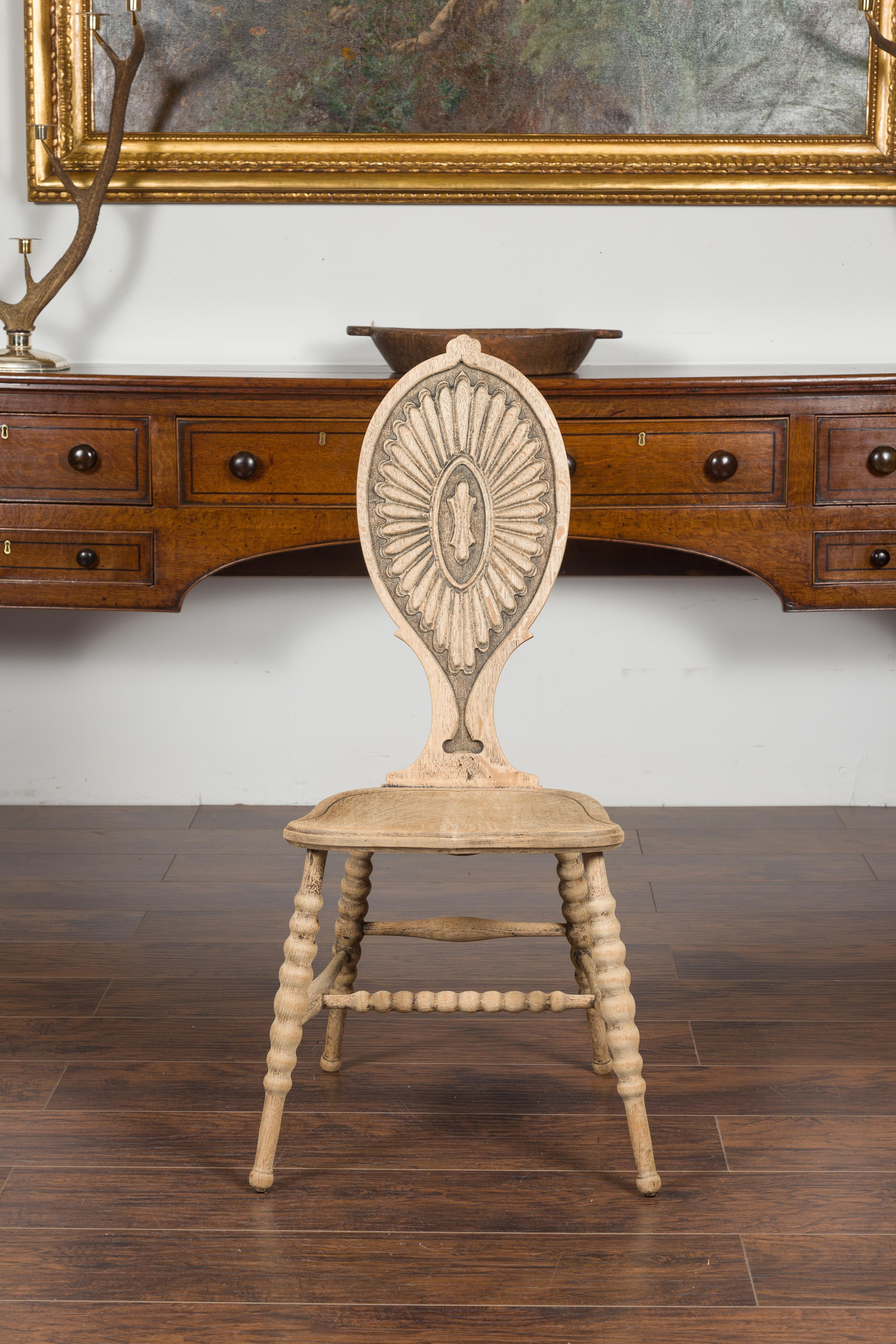 An Austrian Biedermeier style bleached chair from the late 19th century, with bobbin legs and carved back. Created in Austria during the last quarter of the 19th century, this Biedermeier chair captures our attention with its teardrop back carved