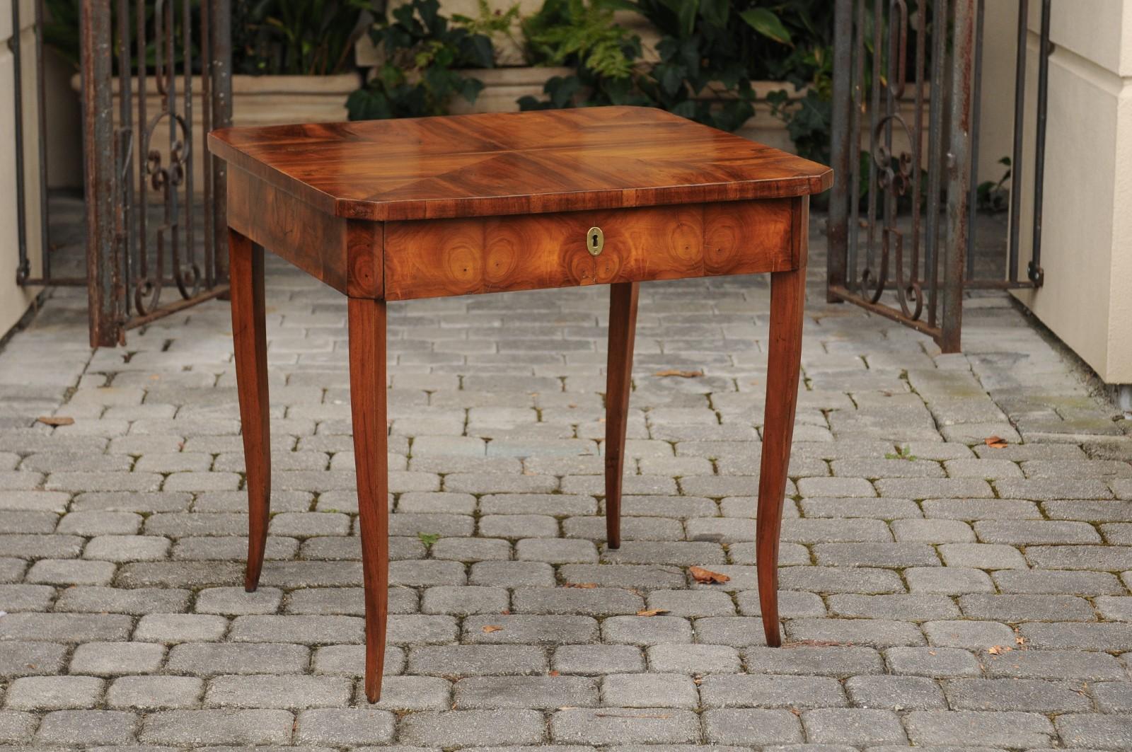 An Austrian Biedermeier walnut table from the first half of the 19th century with bookmark veneered top and oyster veneered apron. Born during the second quarter of the 19th century, this Austrian Biedermeier table features a rectangular top with