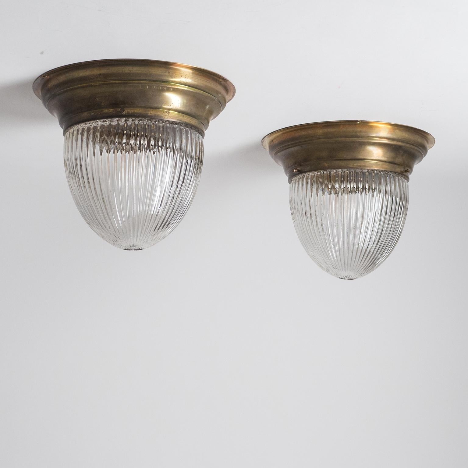 Pair of early 20th century Austrian ceiling or wall lights. Brass backplate with a holophane-style glass diffuser. One original brass and ceramic E27 socket with new wiring. Priced and sold as a pair.