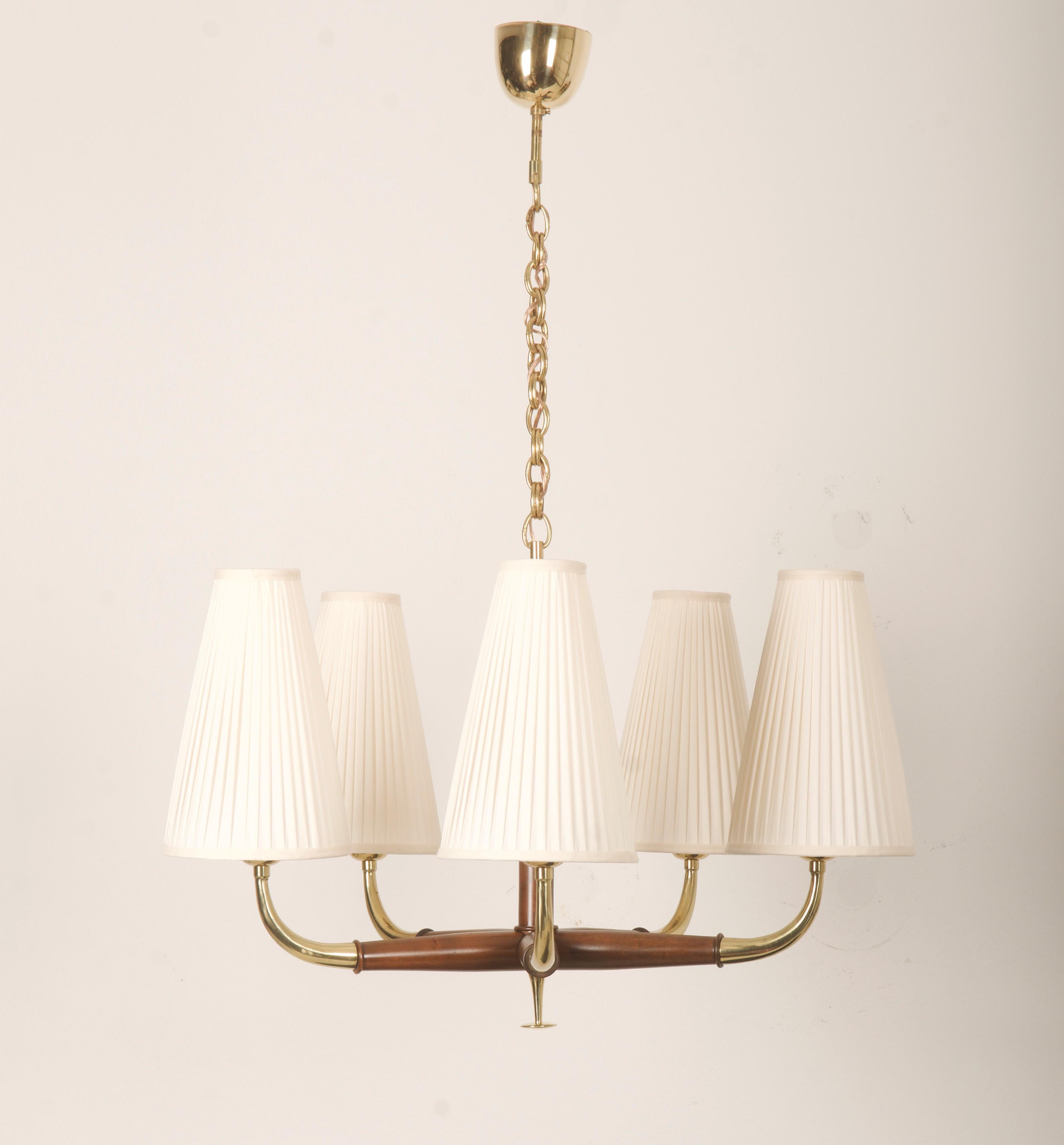 Stella in noce con bracci in ottone con paralumi a forma di cono e dotata di cinque prese E27. Progettata all'inizio degli anni '50 da Oswald Haerdtl per J.T. Kalmar. 
Nuove tonalità.