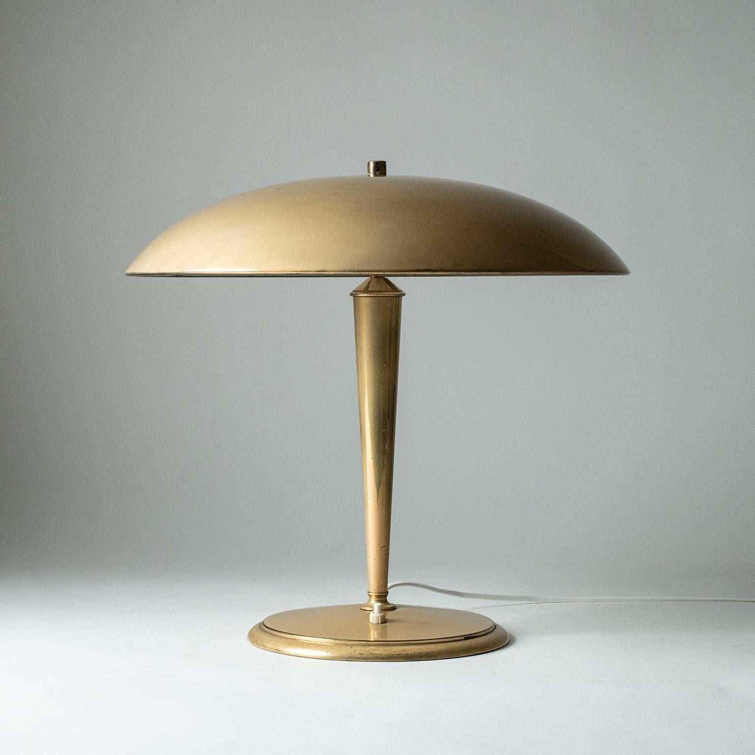 Österreichische Messing-Tischlampe aus den 1940er Jahren. Großer gewichtiger Sockel mit konischem Stiel und großem Schirm, auf der Unterseite weiß lackiert. Ganz aus Messing mit einer ungewöhnlich weichen, matten Oberfläche - möglicherweise