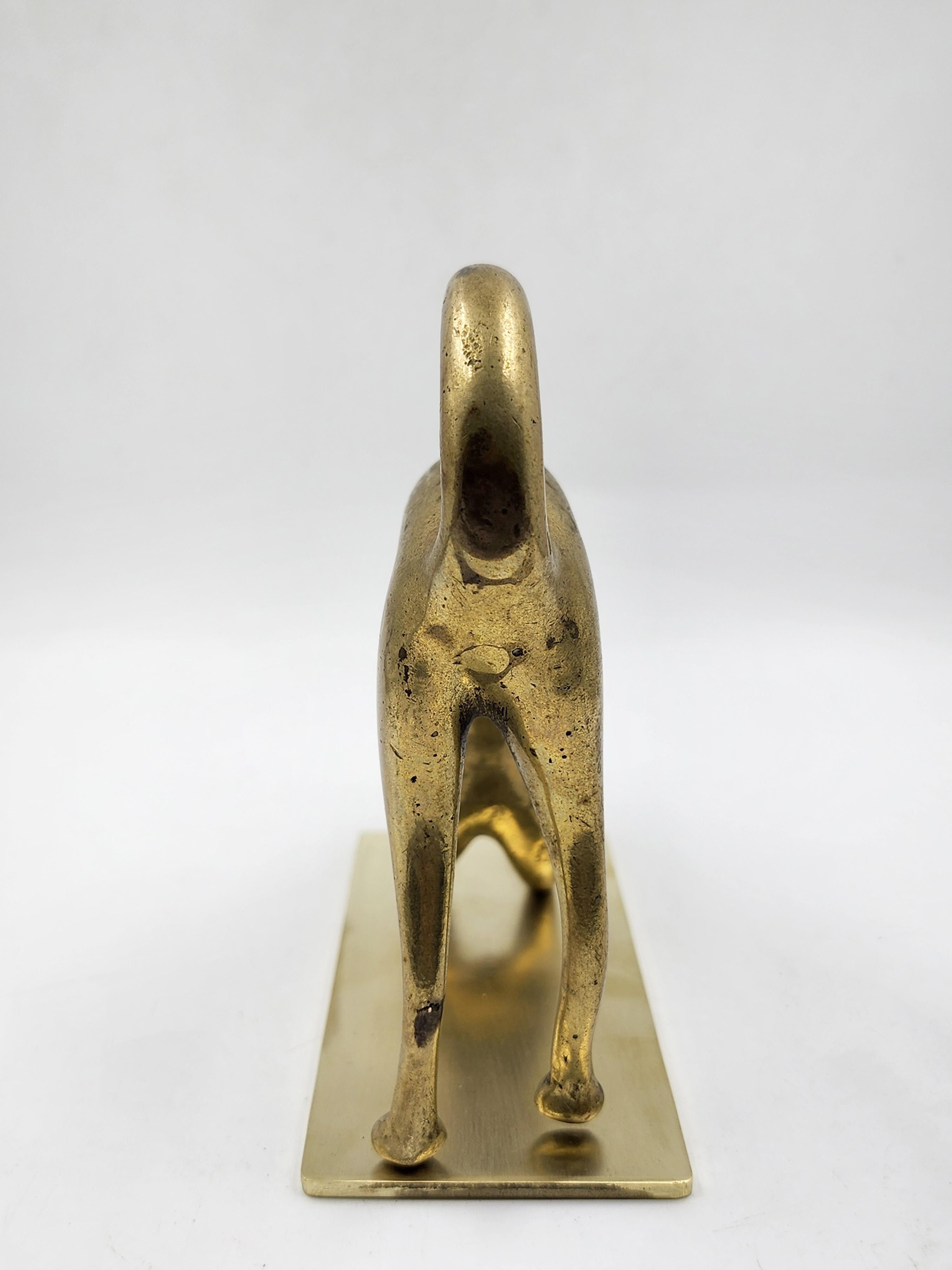 Austrian Bronze Cat Figurine, Hagenauer
This Austrian bronze cat figurine, attributed to Hagenauer, presents the feline in a stretched, arched pose, with its head lowered and its front paws extended forward, while its hind paws remain erect. The