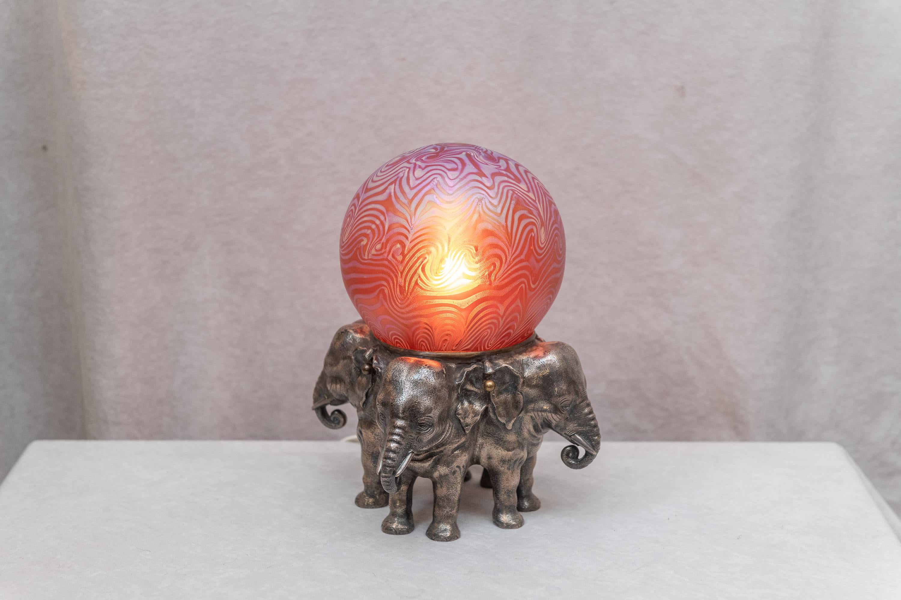 Wenn Sie Elefanten mögen:: ist das hier eine Schönheit. Der Korpus der Lampe ist aus Bronze und wird in Österreich hergestellt:: ebenso wie der mundgeblasene Kunstglasschirm. Der Schirm wurde von einem der besseren österreichischen Glashersteller