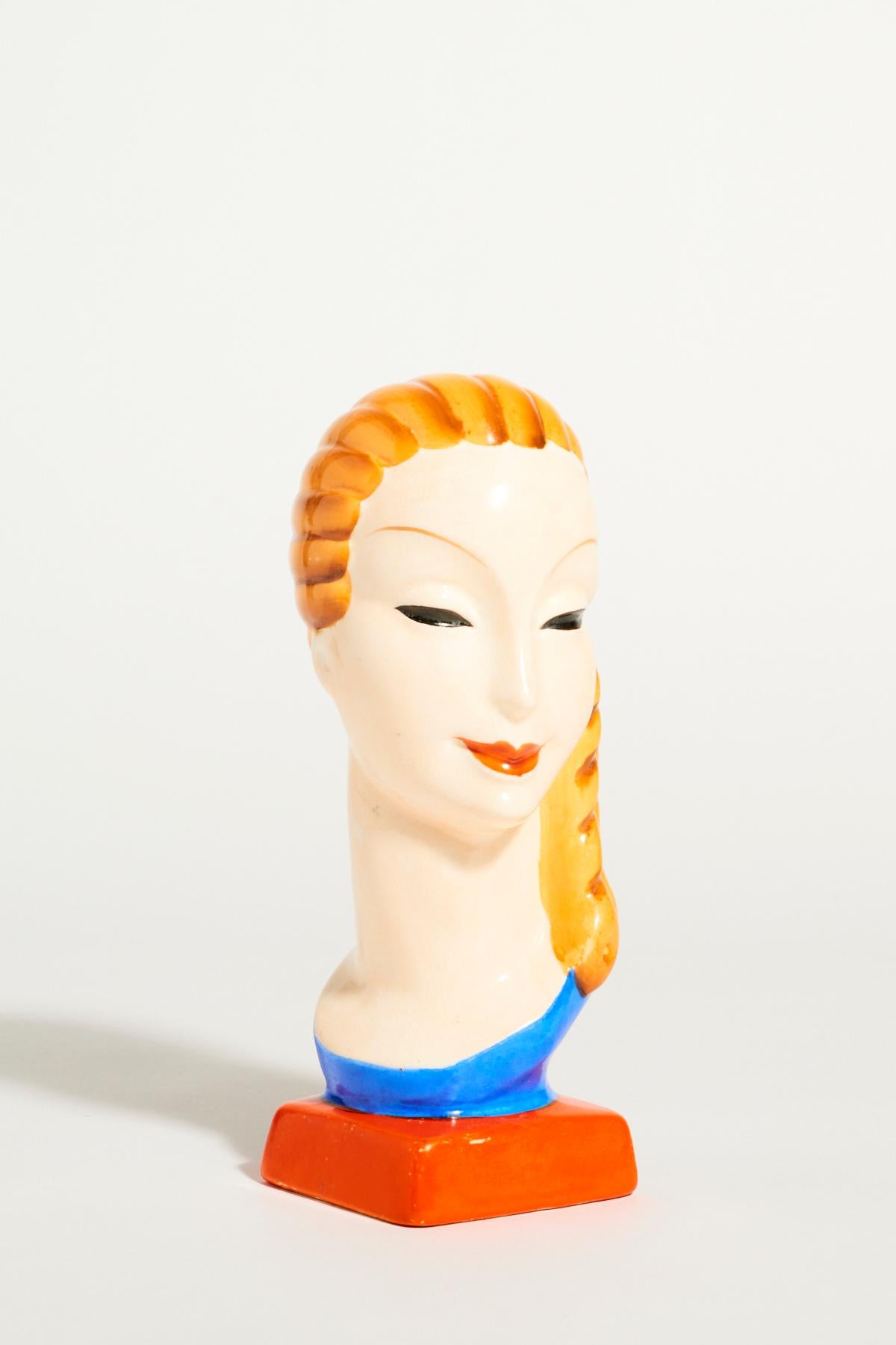A striking deco style ceramic female head in vivid colors, made in Austria.