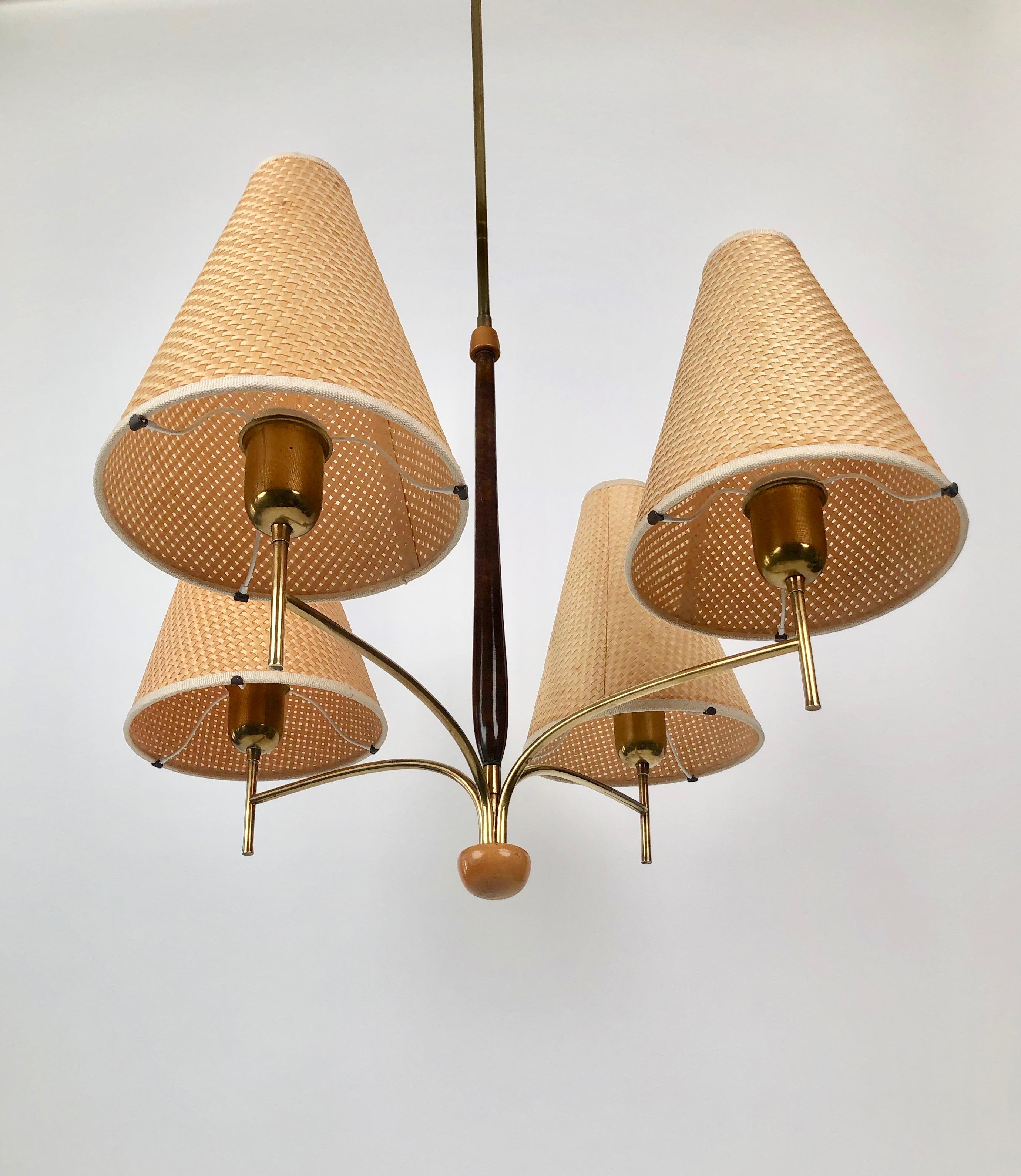 Elegant four shade chandelier from Oswald Haerdtl designed for Haus & Garden and produced possibly from the company Rupert Nikoll in Vienna, 1930´s.

The corpus is made in brass with details in two different woods. 
The original shades are made of