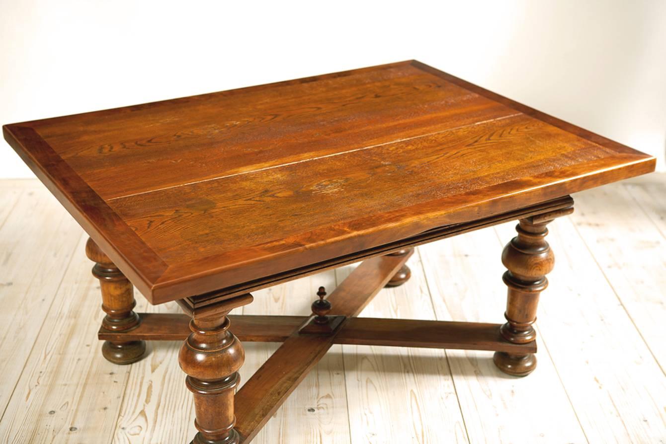 A handsome coffee table with ash wood top banded in walnut resting on bulbous-turned legs that end in bun feet with 