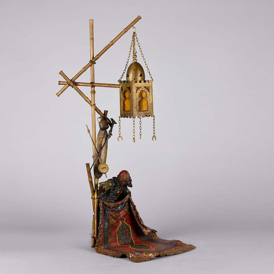 An excellent early 20th century Austrian cold painted bronze lamp of an Arab man selling a highly detailed Oriental carpet, with very fine colour and carefully chased surface detail. The inside fitted with an electrical light, rewired and signed to