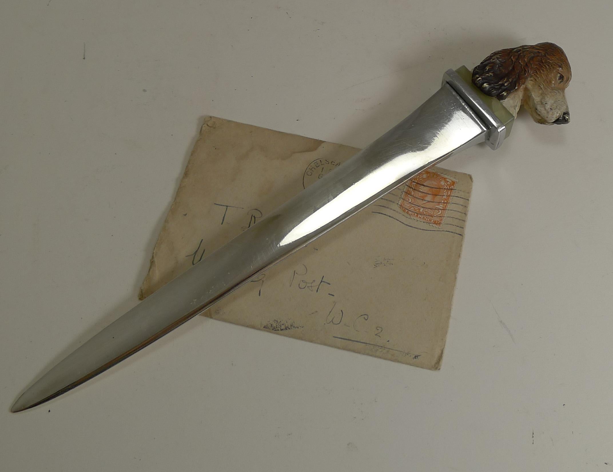 A fabulous and very handsome desk-top letter opener, the blade is nickel over brass or bronze and the terminal, which is of course the main event, is a cast bronze head of a Spaniel.

The dog sits on a block of green onyx and is cold-painted with