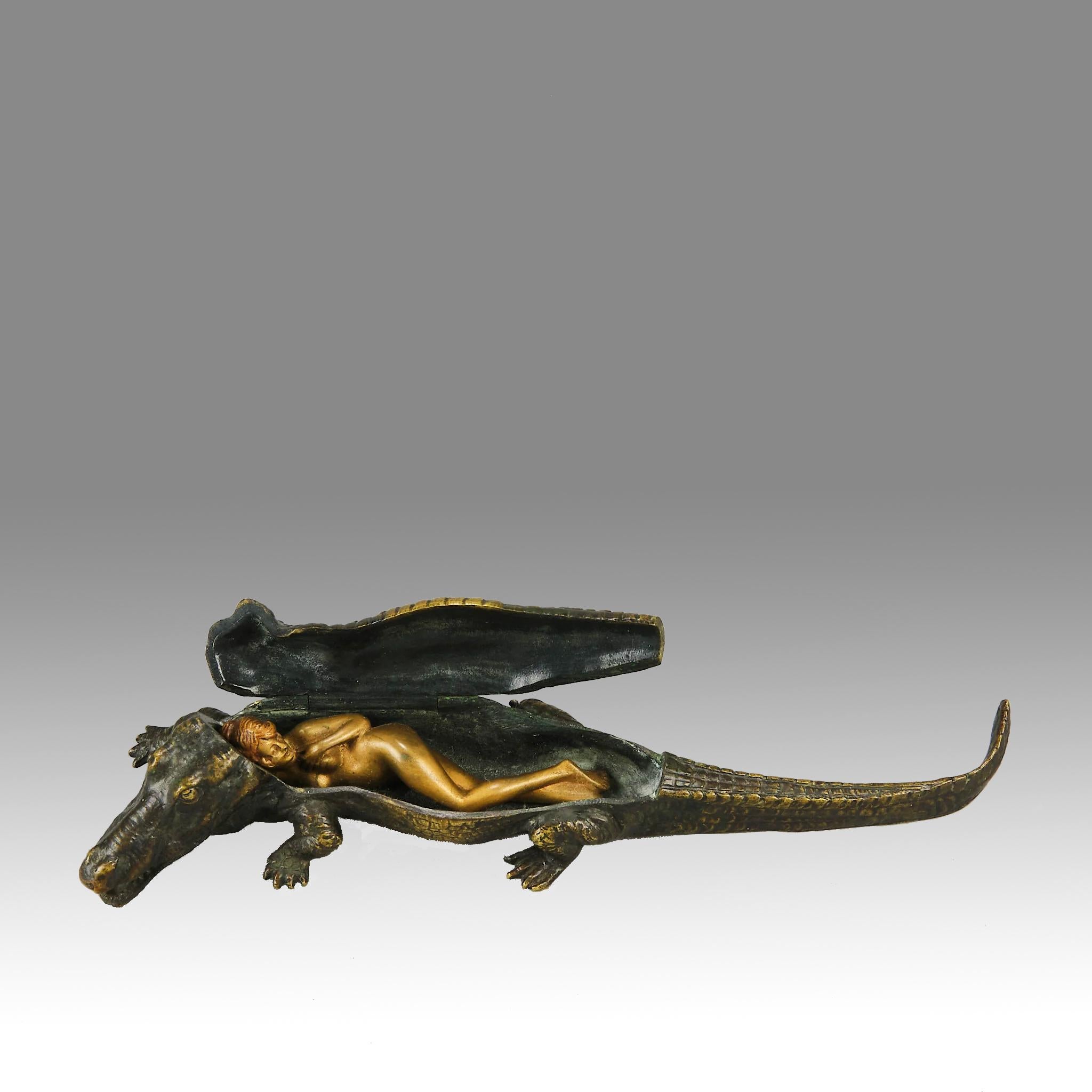 An interesting early 20th Century erotic Austrian bronze study of a walking crocodile. The crocodile's back is hinged to reveal a gilt bronze naked beauty reclining within the reptile's interior with very fine detail and colour, signed with the
