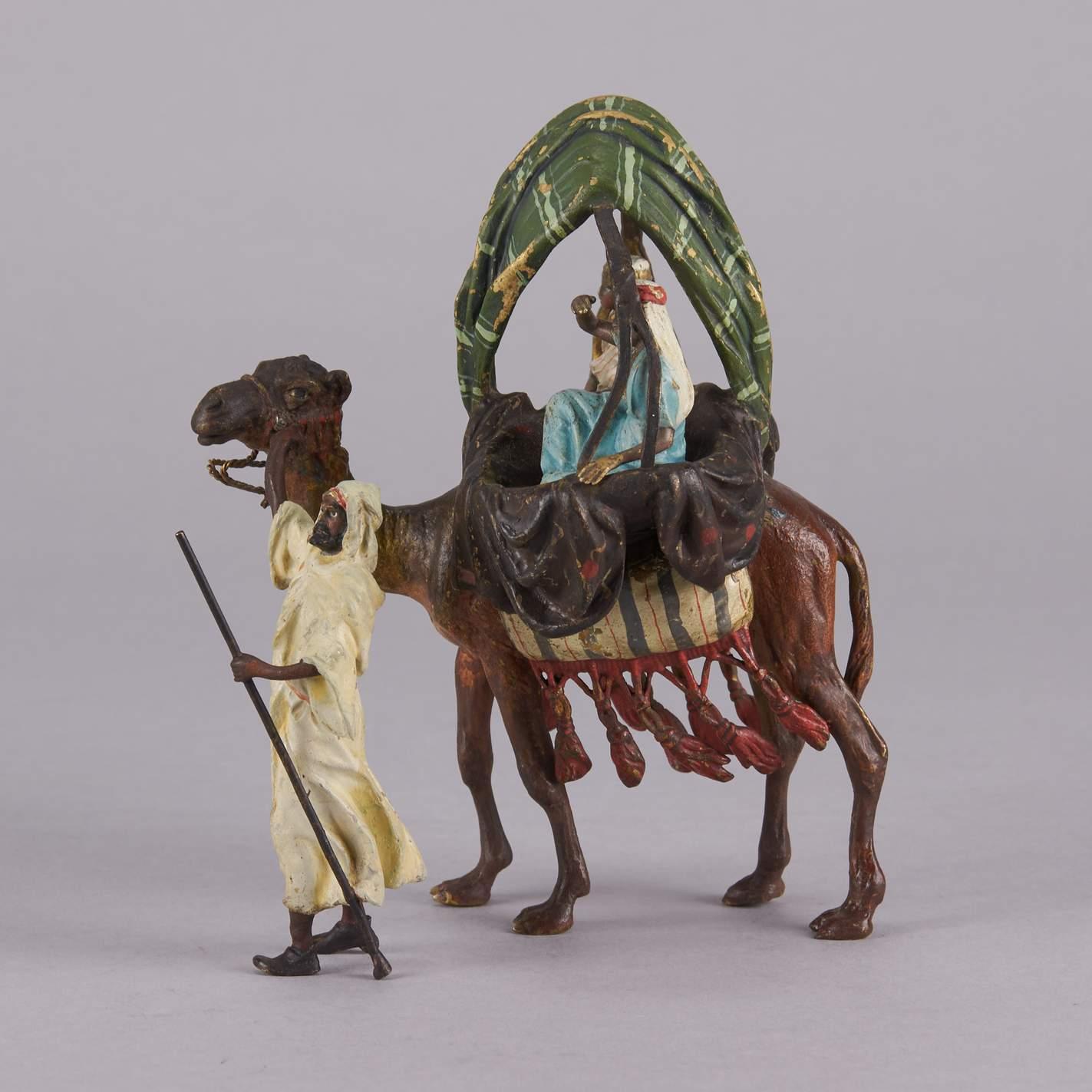 Fascinating early 20th century Austrian bronze group of an Arab leading a camel with tented twin saddle carrying two young women in full attire. The surface of the bronze with rich cold painted colours and very fine hand finished detail, signed with
