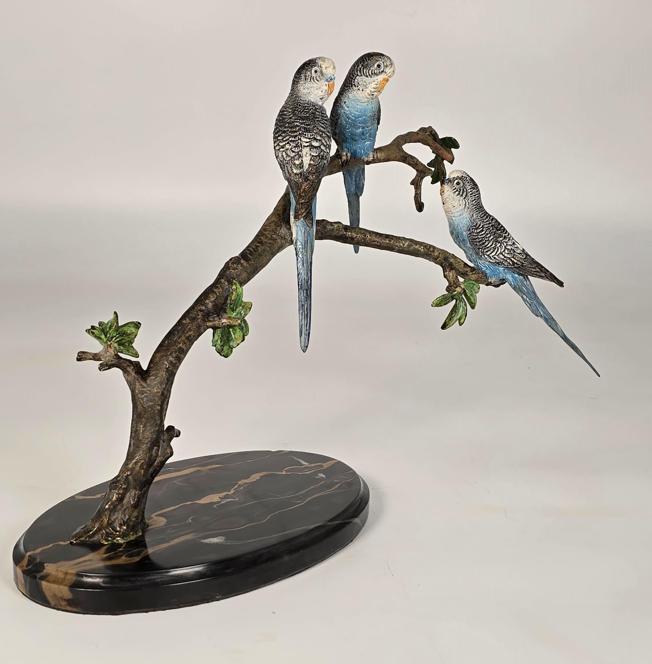 Este bronce austriaco a gran escala representa a tres periquitos azules posados juntos en una rama frondosa. El modelado y el estado de conservación de este bronce son magníficos. Los detalles de las plumas pintadas son frescos y brillantes, lo que