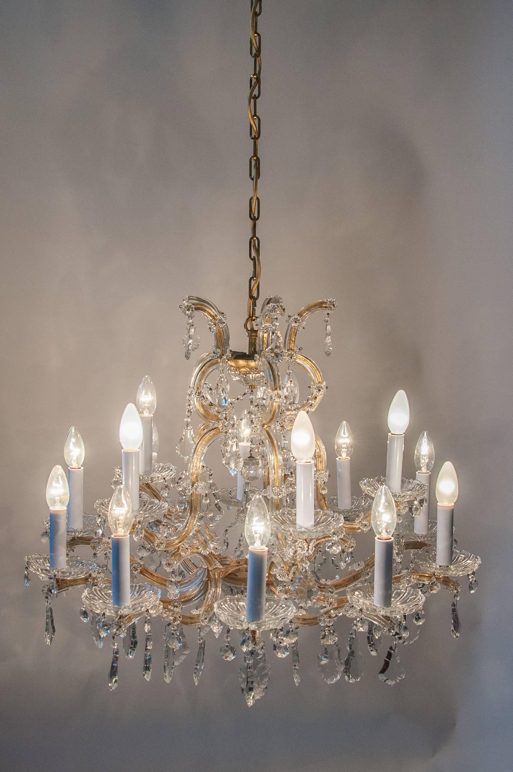 A very elegant and hard to find 15 socket crystal chandeliers with glaced sides from Vienna. 
The Chandelier is handmade of iron and set in gold color, handworked finish. The dressing of the chandelier is featuring a traditional assembly of crystals