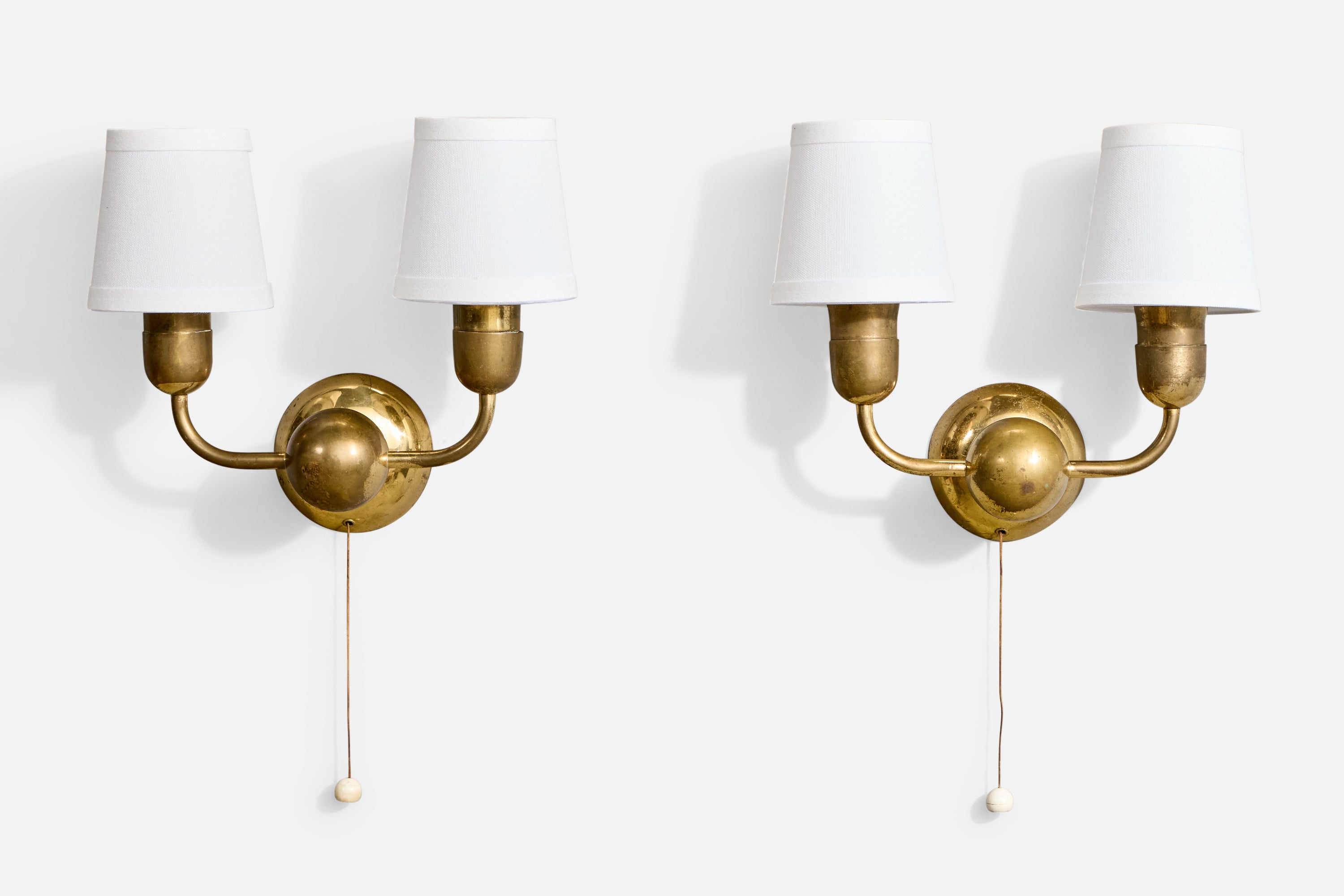 A pair of brass and white fabric wall lights likely designed and produced in Austria, c. 1950s.

Overall Dimensions (Inches): 9.25
