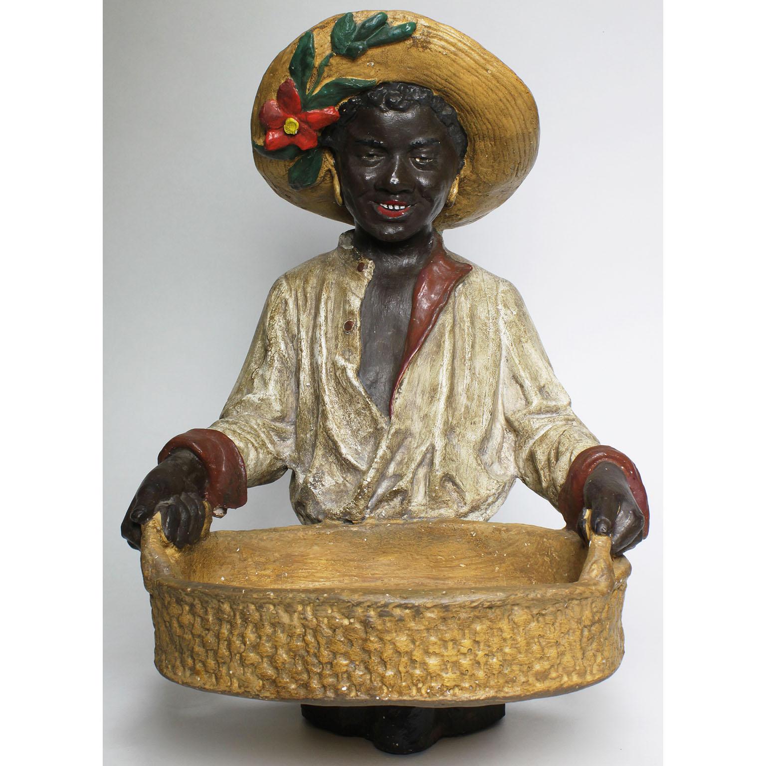 An Austrian early 20th century cast bust figure of an African girl holding a tray. The smiling young girl wearing a straw hat decorated with a flower and leaves, holding weaved-wicker-like tray, probably by Goldscheider's Porzellan-Manufactur and