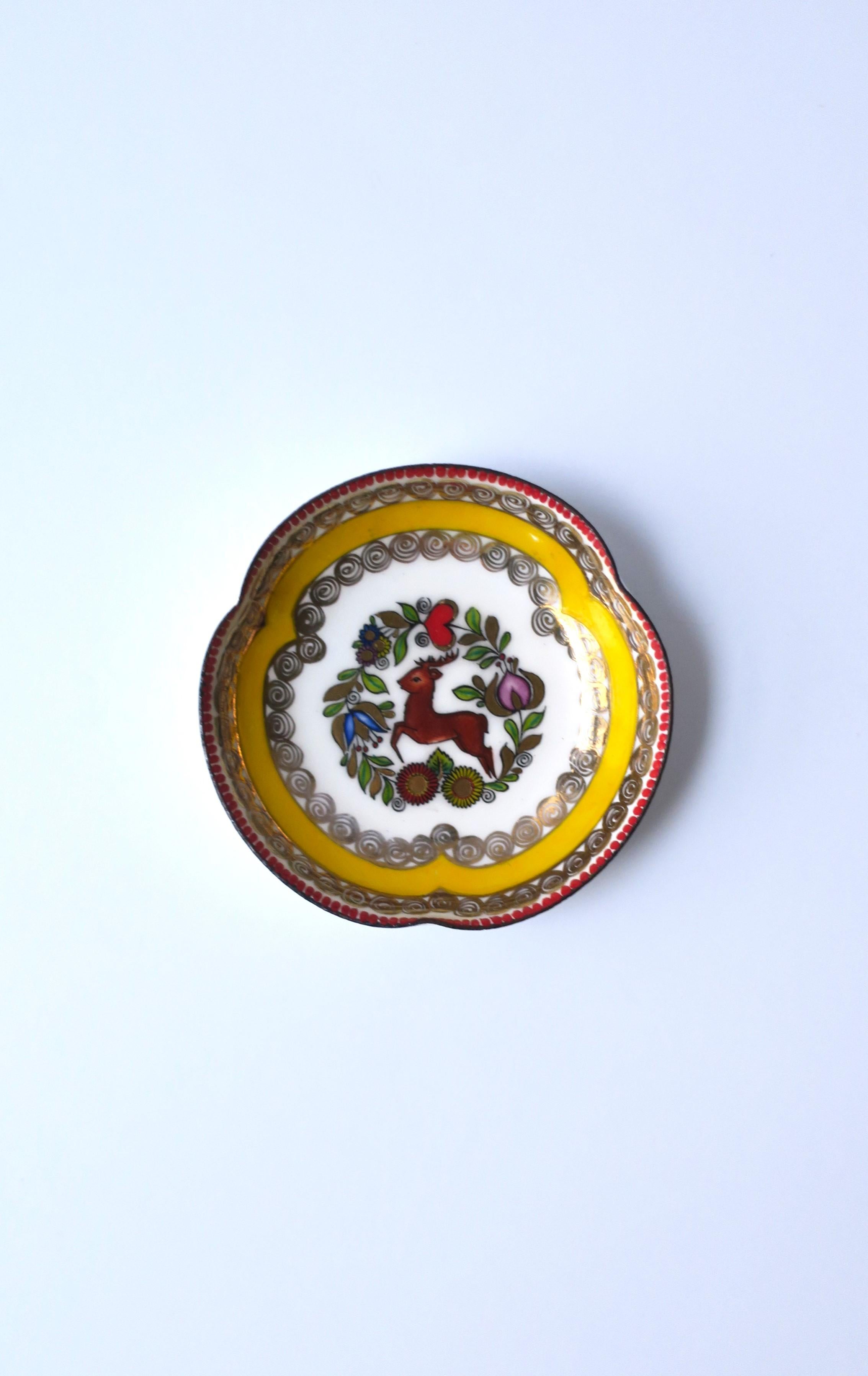 A colorful porcelain enamel Austrian small bowl or jewelry dish, circa mid-20th century, Austria. Dish, with a white enamel ground, features detailed Austrian stag deer at center, finished with yellow and gold detail around inside edge. A great