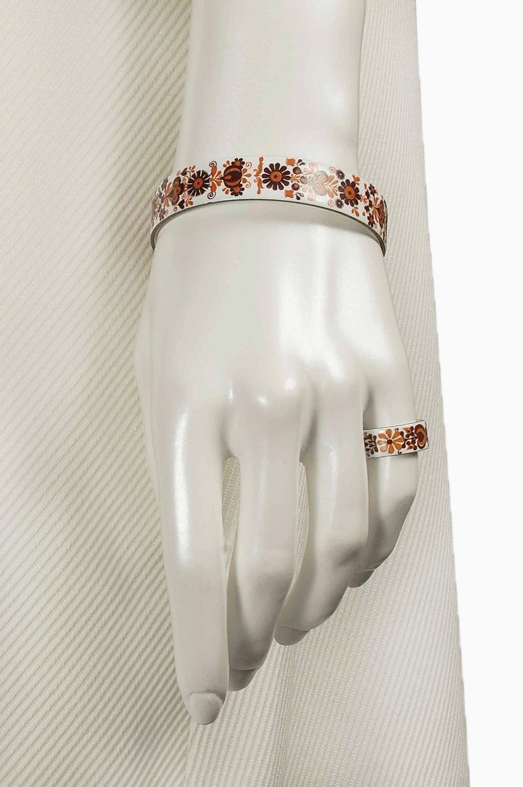 I gioielli in smalto austriaco passano attraverso ben 100 fasi individuali per raggiungere la loro intricata bellezza. Questo set vintage presenta un motivo floreale delicatamente dipinto a mano i cui colori bohémien evocano perfettamente la metà