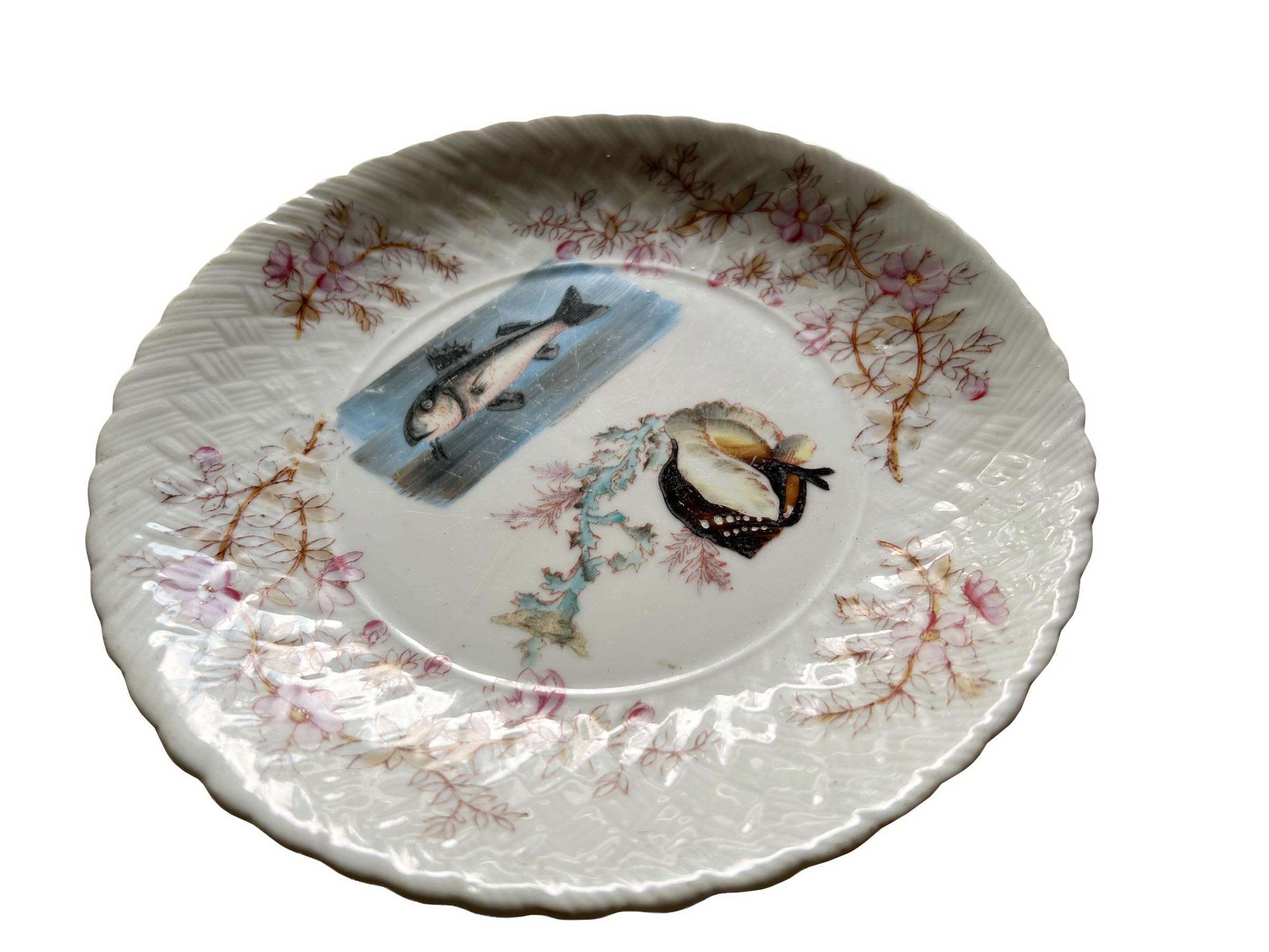 Assiette à poisson en porcelaine ancienne peinte à la main avec une belle bordure à décor floral. De beaux détails.
 