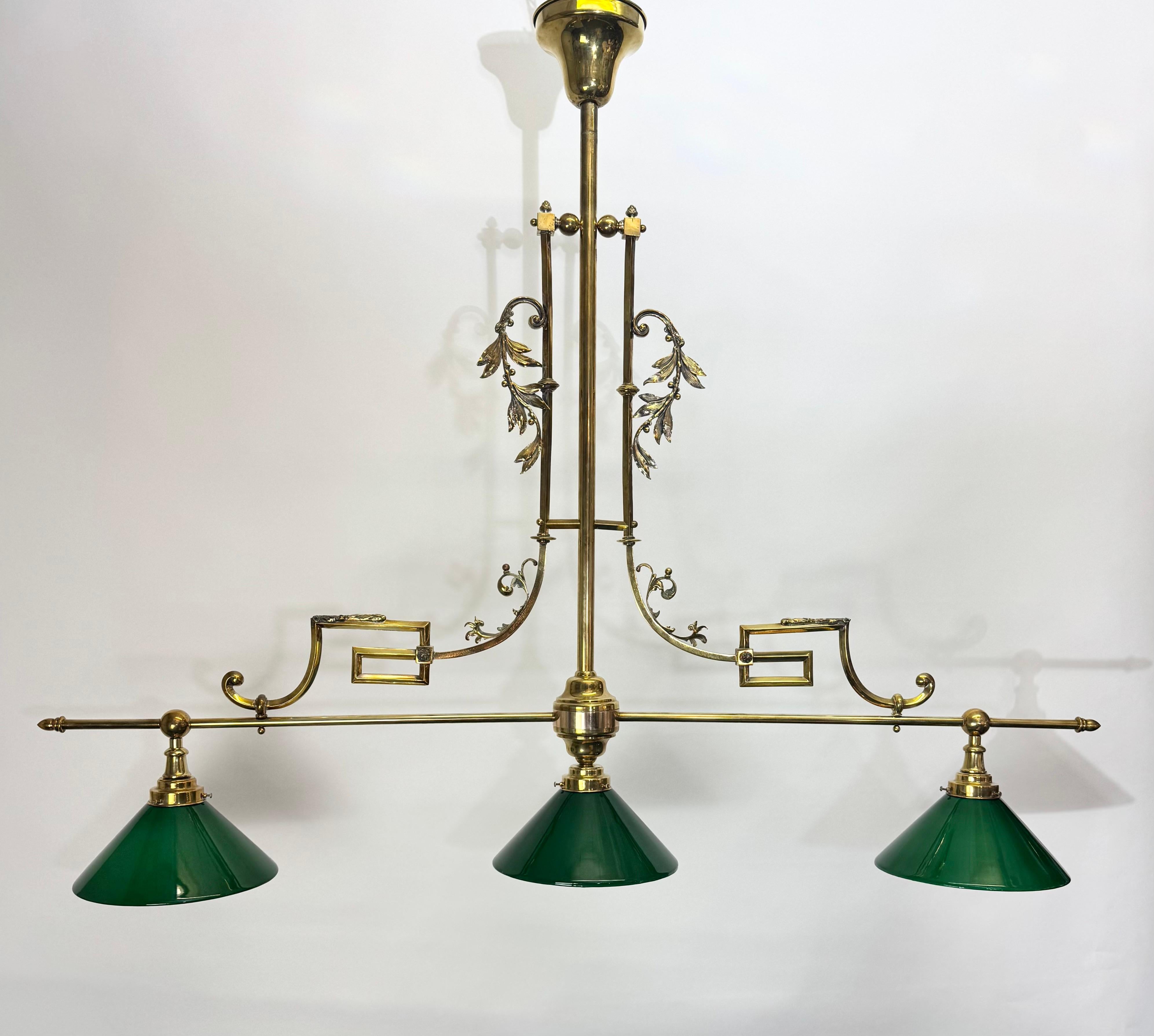 Ancienne lampe de billard / bibliothèque à trois lumières de Vienne, vers 1900. Fabriquée en laiton doré (à l'origine plaqué argent) avec des détails décoratifs et équipée de trois abat-jour en verre vert soufflé à la main. Entièrement restauré et