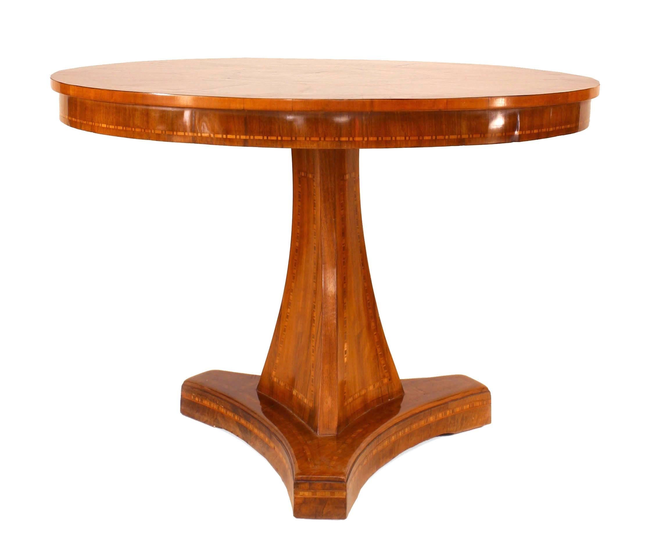 Continental Austrian (circa 1820) walnut round center table with an inlaid figure on horse centered in inlaid rings and supported on a triangular pedestal and base.
