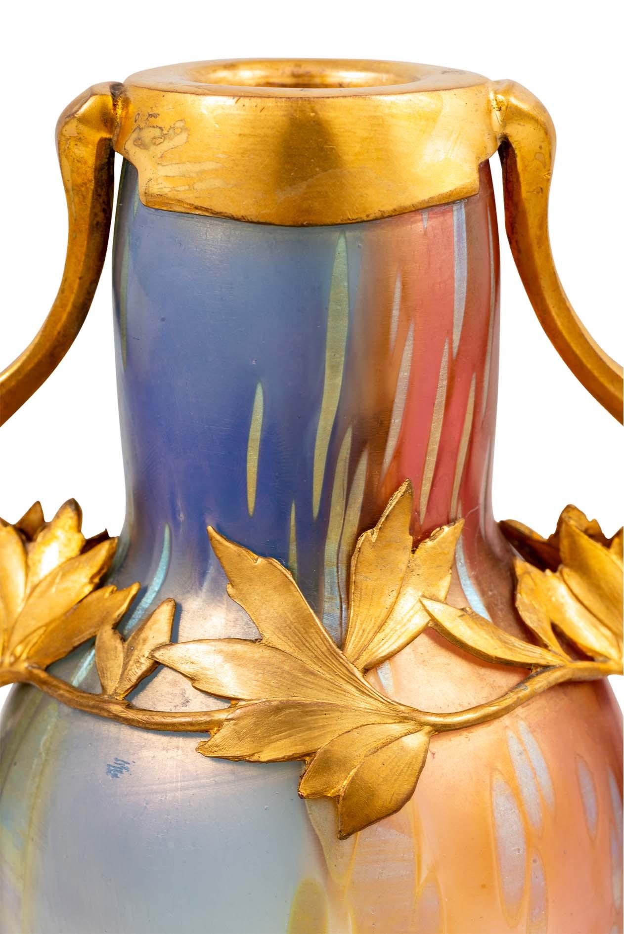 Glasvase hergestellt von Johann Loetz Witwe Tricolore Dekoration Zinn-Metallfassung entworfen von Bitter & Gobbers ca. 1900 Österreichischer Jugendstil vergoldet formgeblasen reduziert und irisierend Regenbogenfarben Blau Rot Grün Gelb

Diese