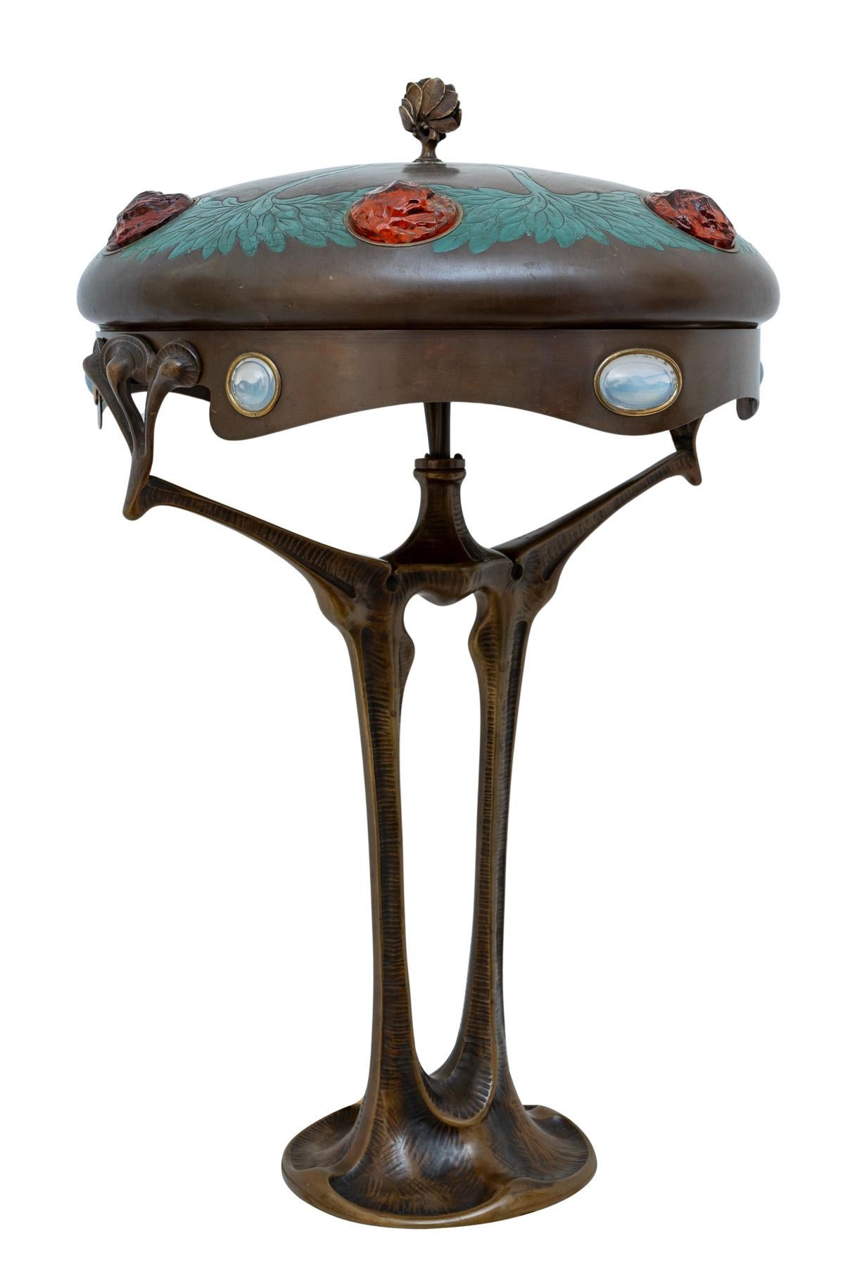 table lamp, designed by Adolf Josef Pohl, Vienna, ca. 1905

Our lamp not only impresses as a masterful work of art, it also impresses in its function as a lamp with its warm radiance in which the red-orange framed opal glass stones come into their