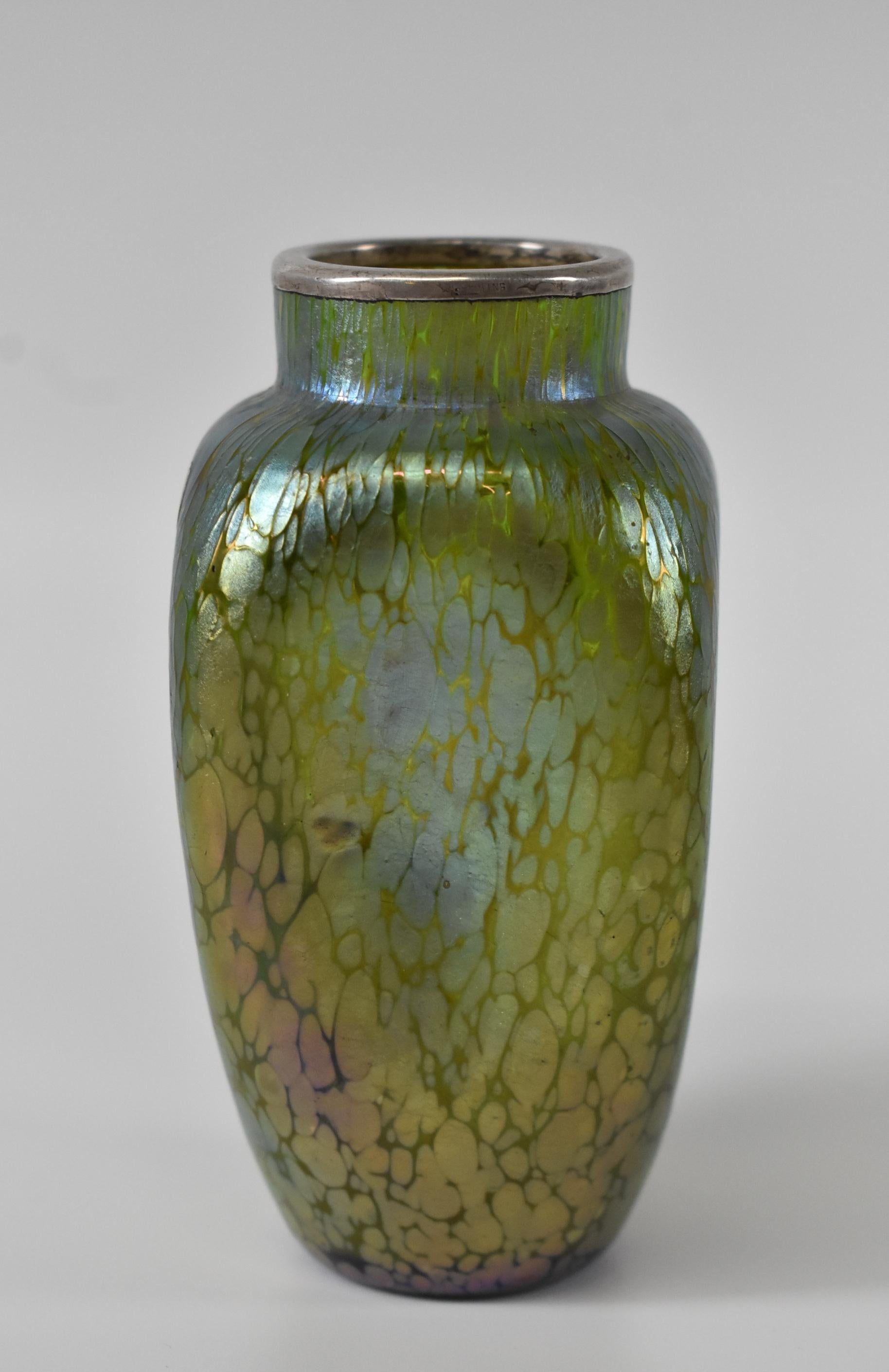 Vase d'art autrichien Loetz en verre irisé, finition papillon avec recouvrement en argent sterling. Style Art Nouveau dans une forme alvéolée dans des tons de vert, de bleu et de violet. Très bon état. Dimensions : 2.25
