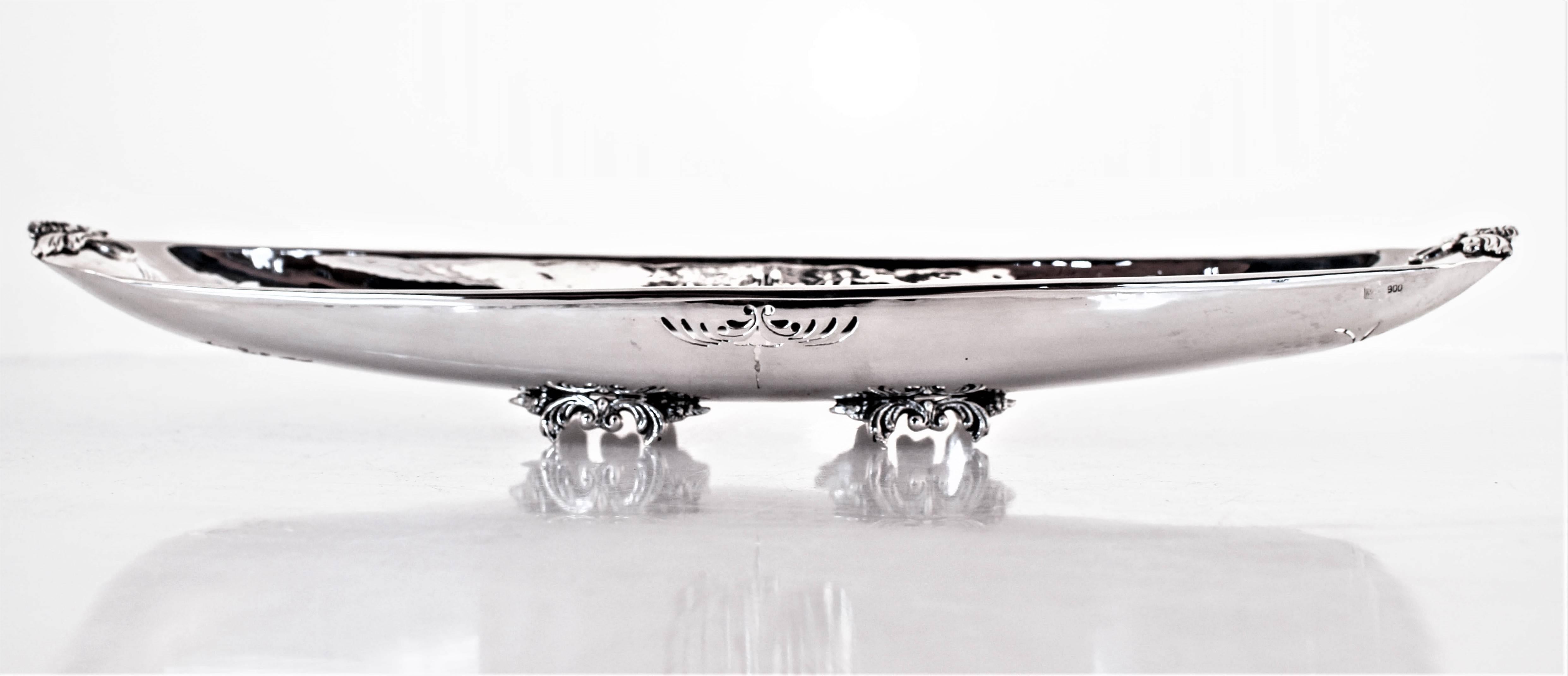 If you’re looking for something different or unique, read on because this piece is unusual. A very long and narrow dish that stands on four legs. It has a light touch of hammering and pierced work on each end. It would be perfect filled with bonbons