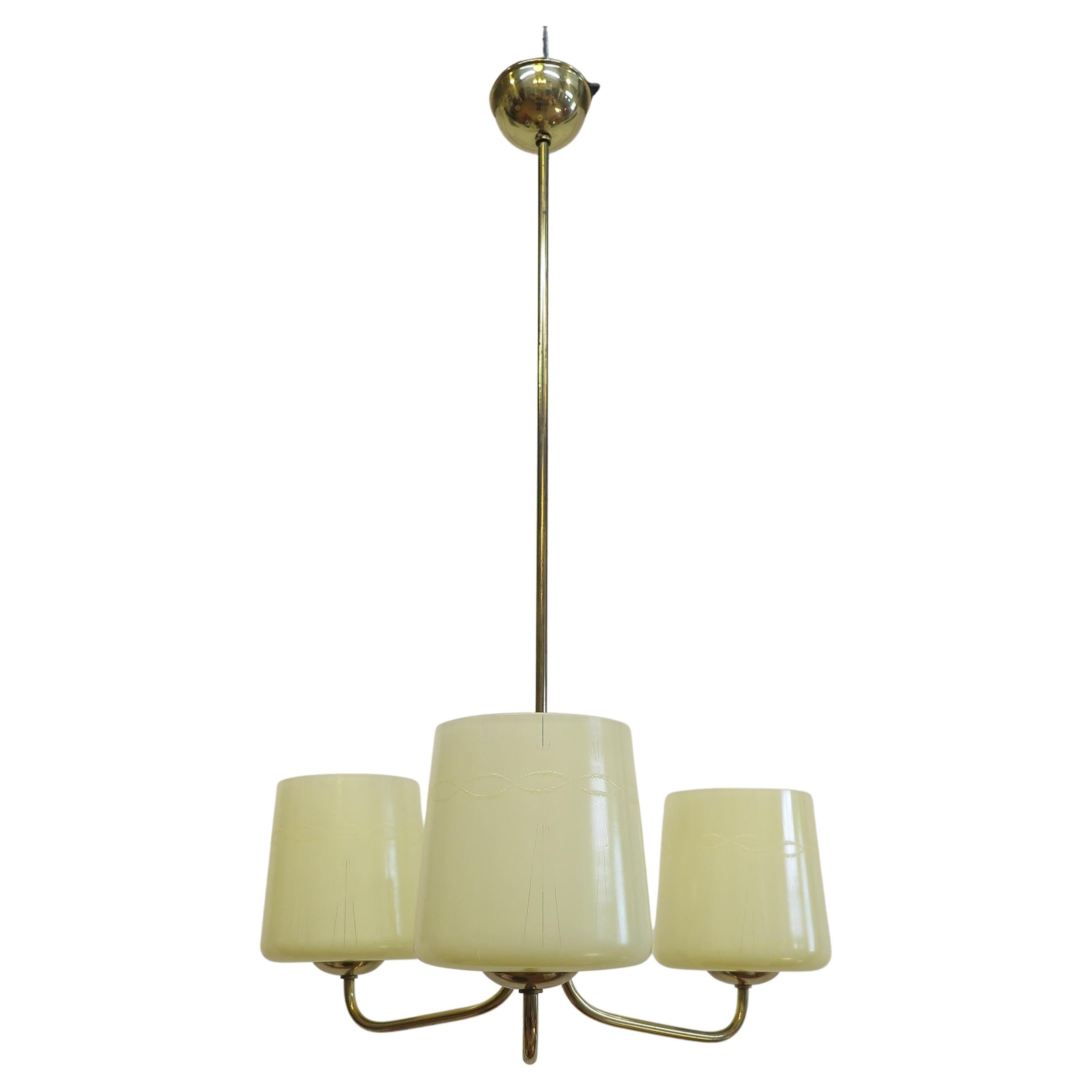 Austrian Mid-Century Modern brass and opaline glass chandelier. Three arm modernist brass chandelier with slightly tapered opaline glass shades having a light etched design. Elegant modernist lines of the arms supporting snifter styled glass shades.