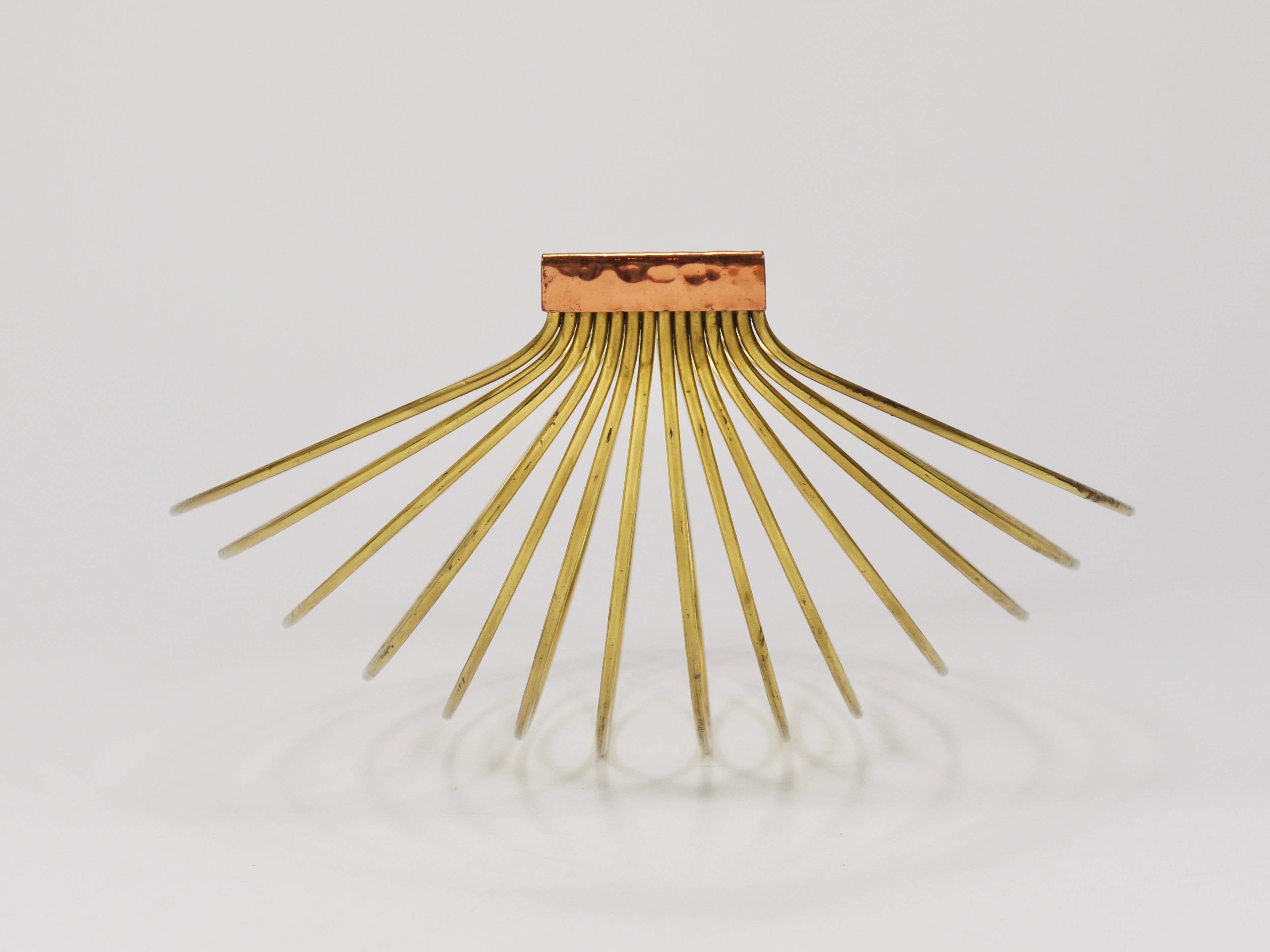 A sleek and minimalistic yet sculptural modernist fruit basket, handcrafted in Austria during the 1950s. Made from brass and hammered copper, it is in good condition with delightful patina. Dimensions: 12 1/2