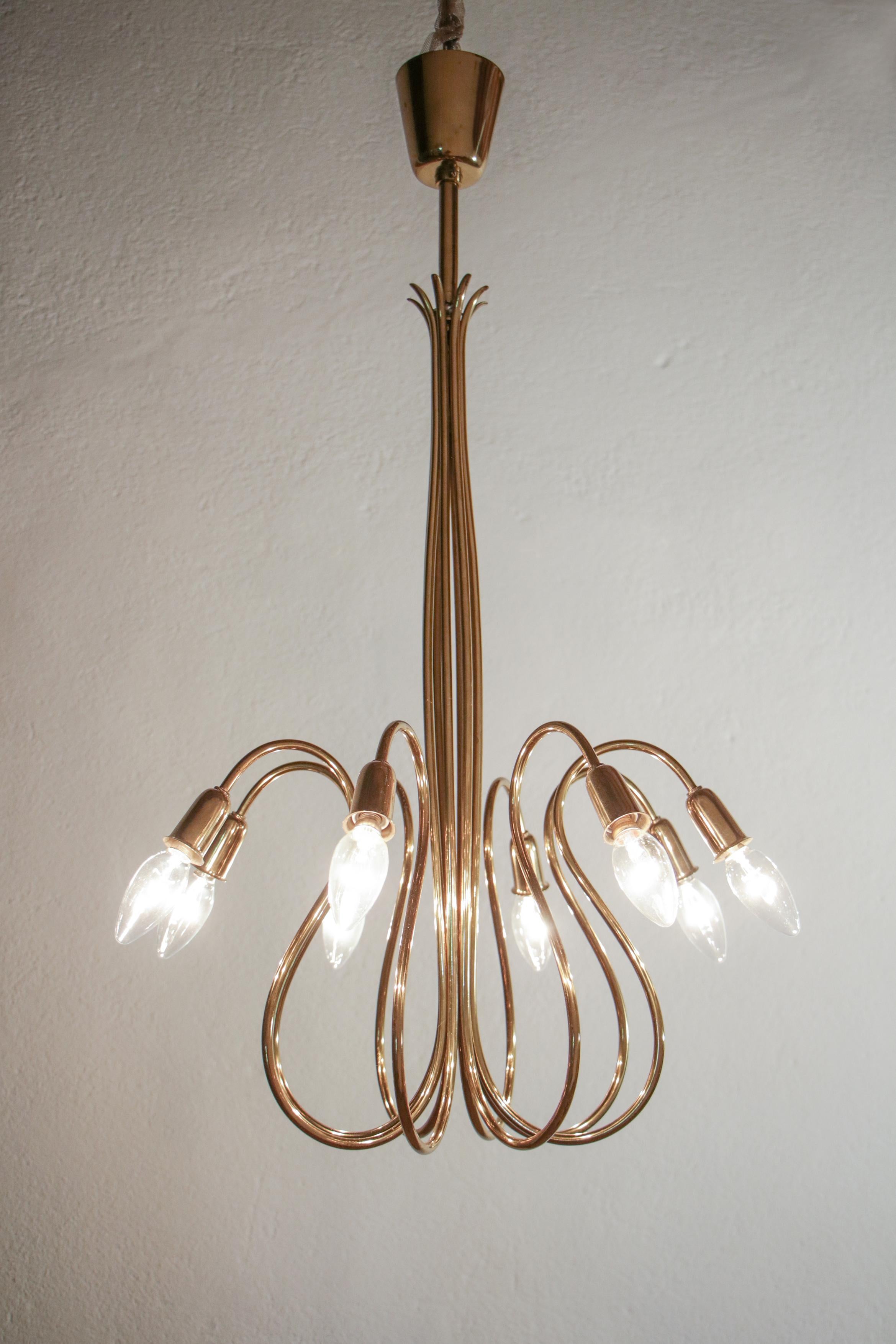 Splendid Austrian mid-century octopus shape chandelier with eight lights in E14 format, attributed to J.T. Kalmar, produced in the 1950s. The octopus chandelier is entirely made of bright brass. The line is elegant and represents a great executive